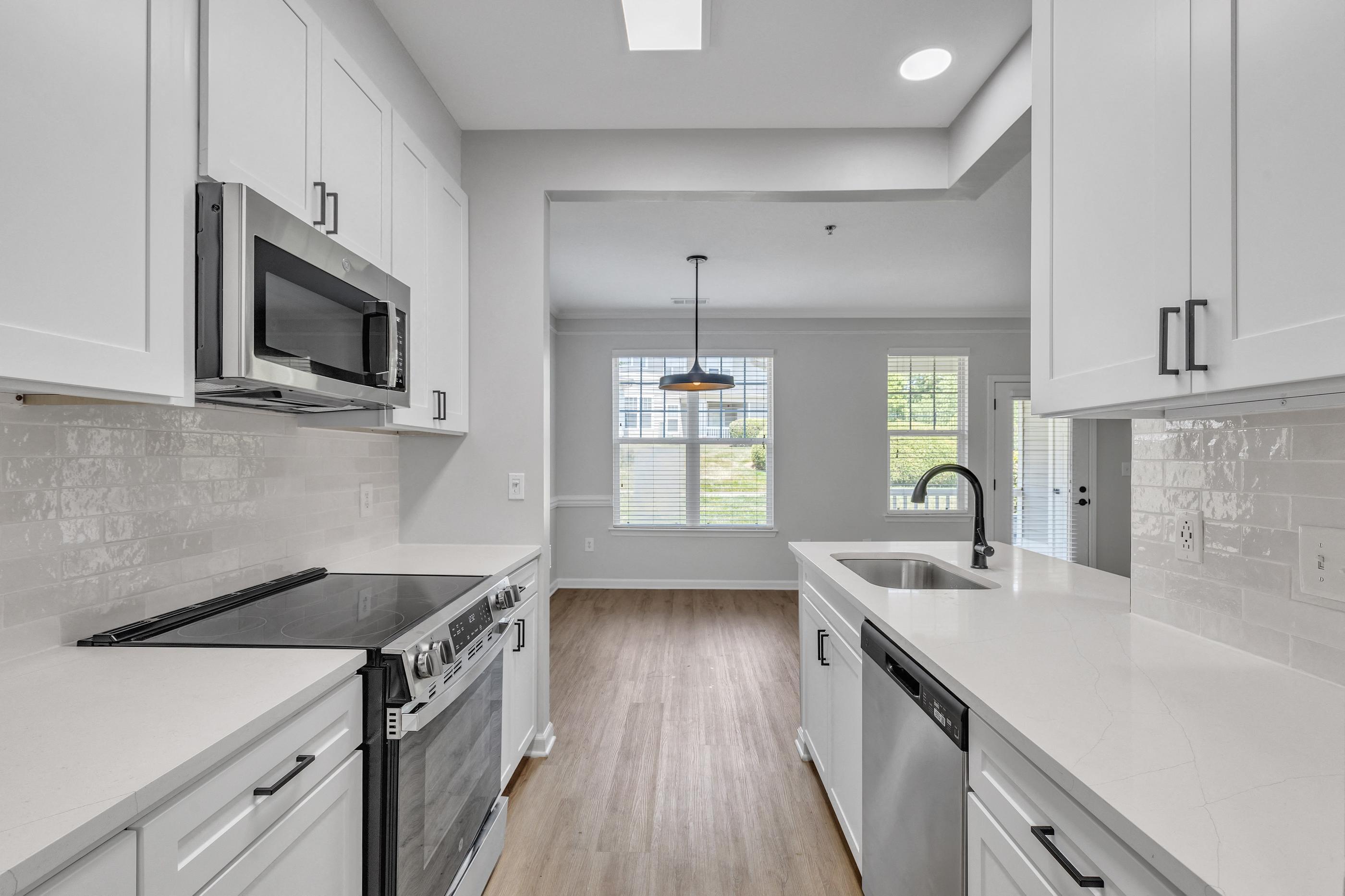 A kitchen with white cabinets and a black stove top oven.