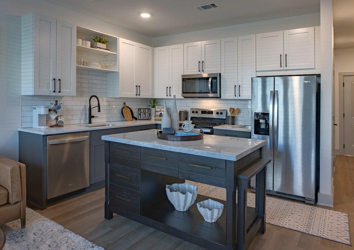 a large kitchen with stainless steel appliances and white cabinets