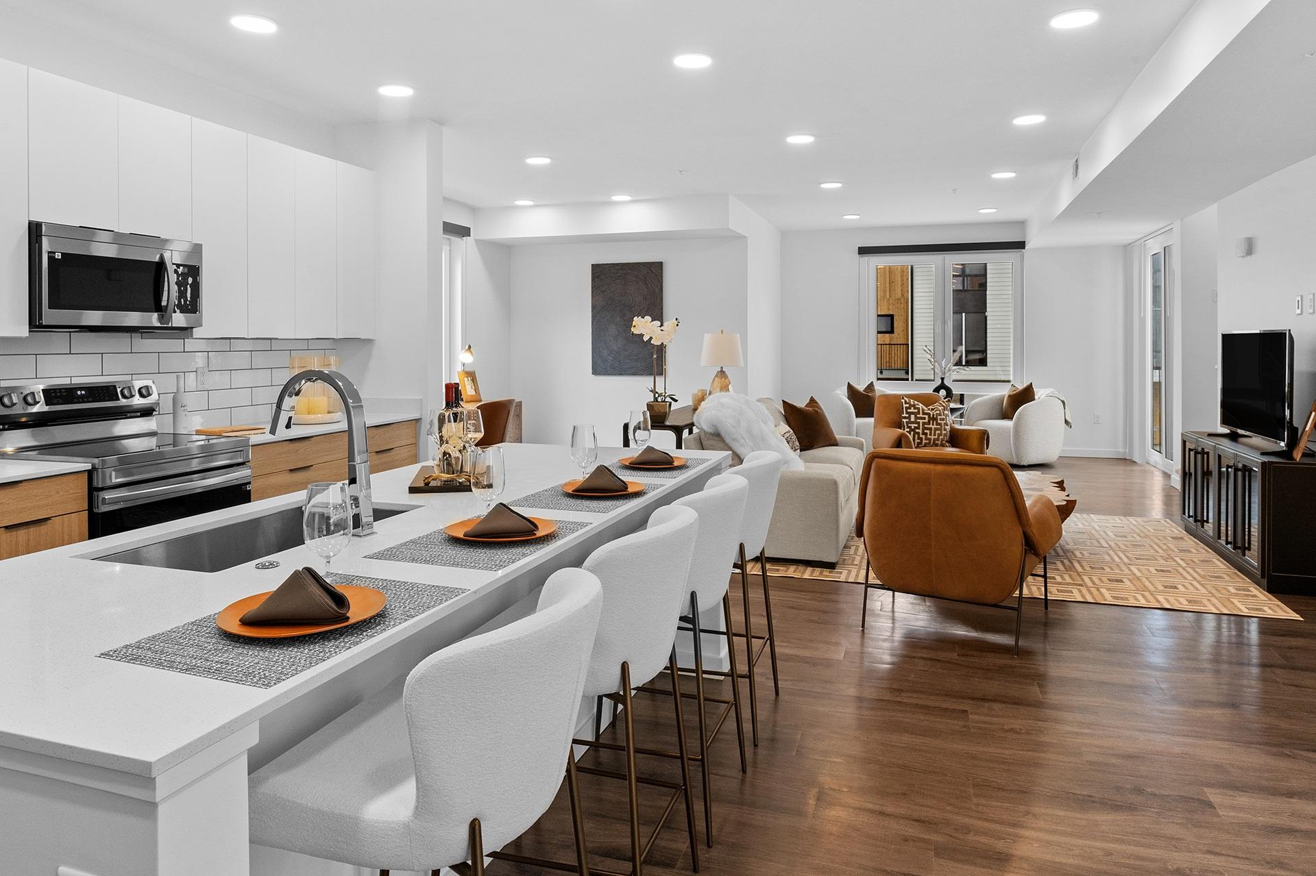 A modern kitchen with white cabinets and a long white island.