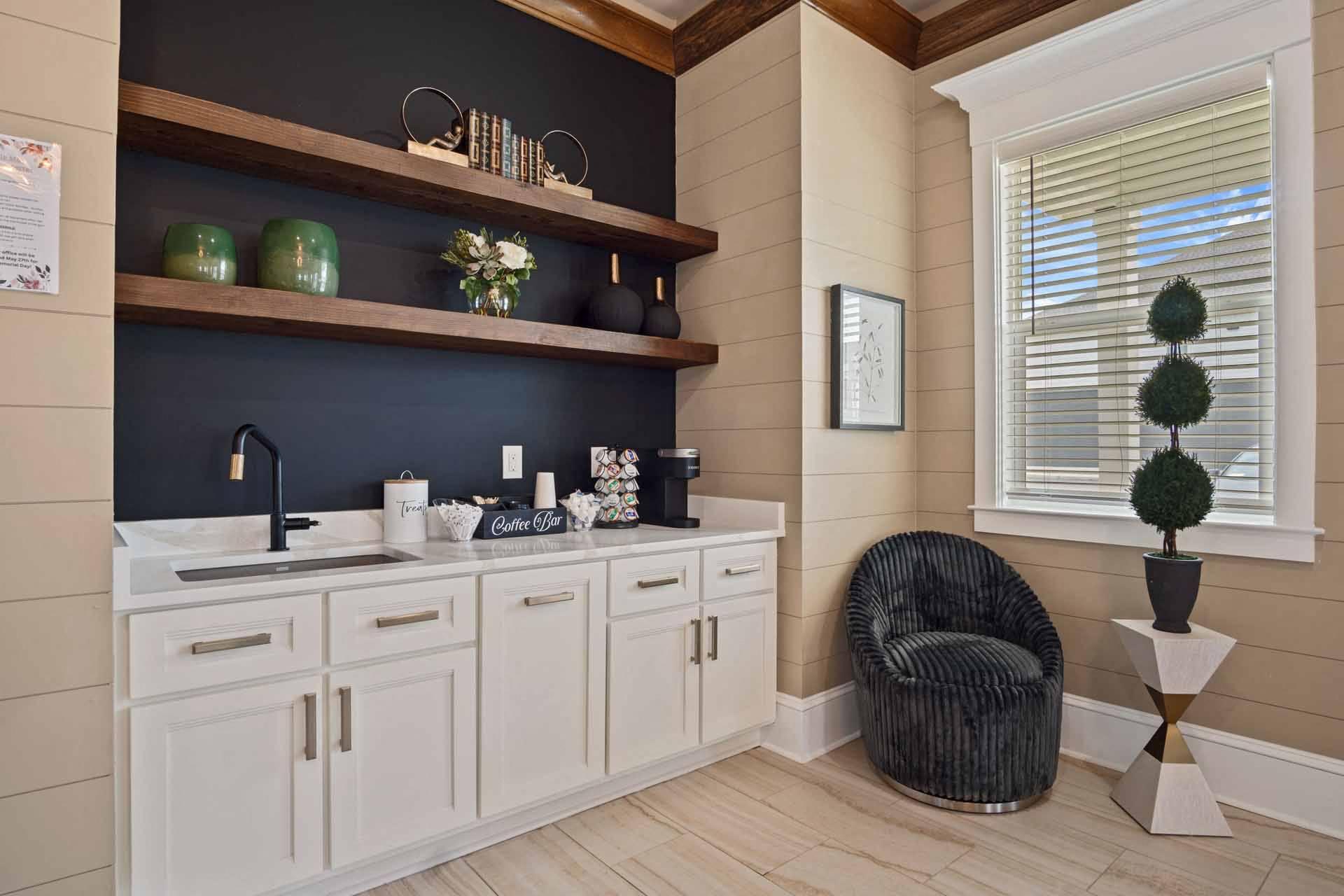 A kitchen with white cabinets and a black countertop.