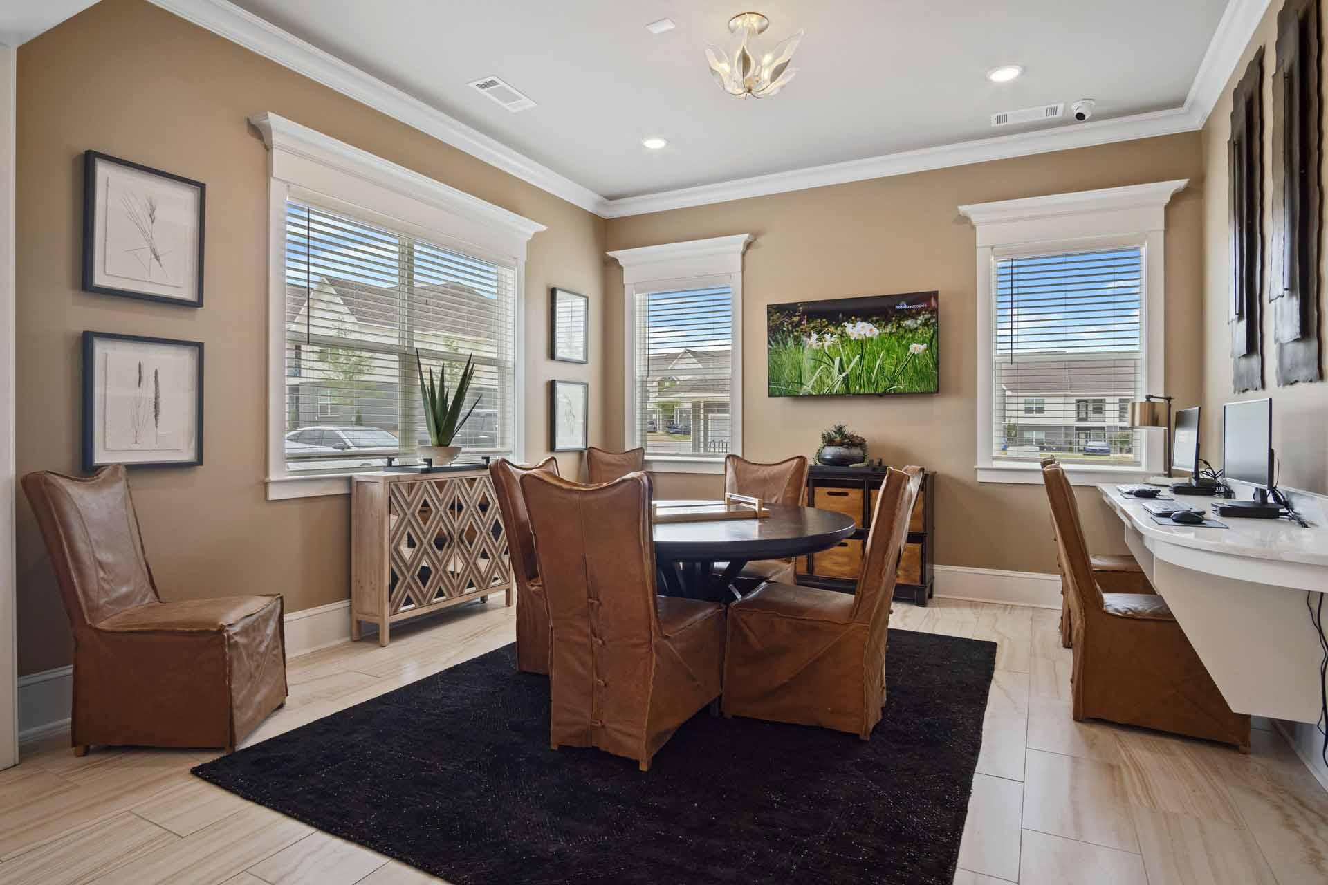 A living room with brown leather chairs and a black rug.
