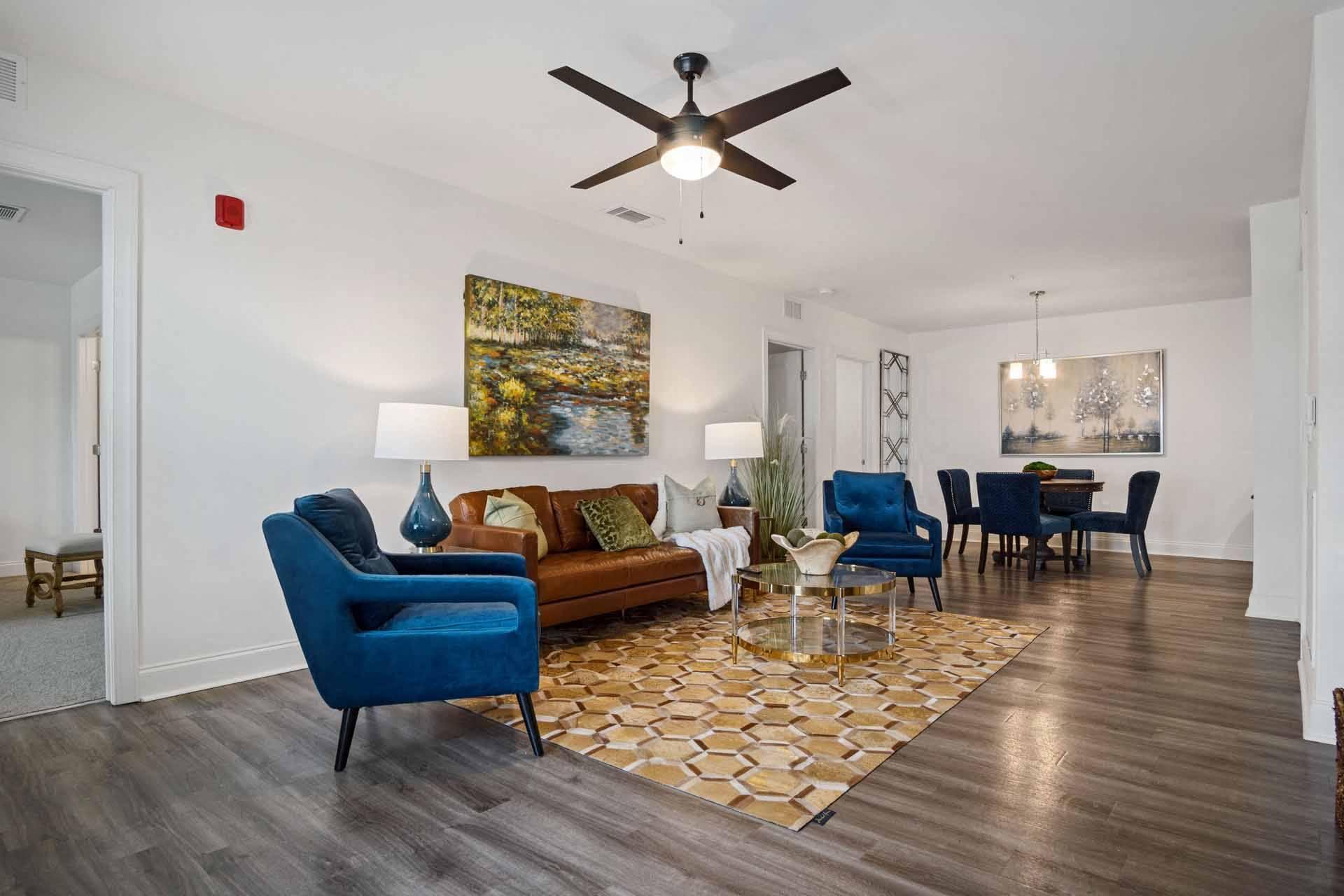 A living room with a blue chair and a brown couch.