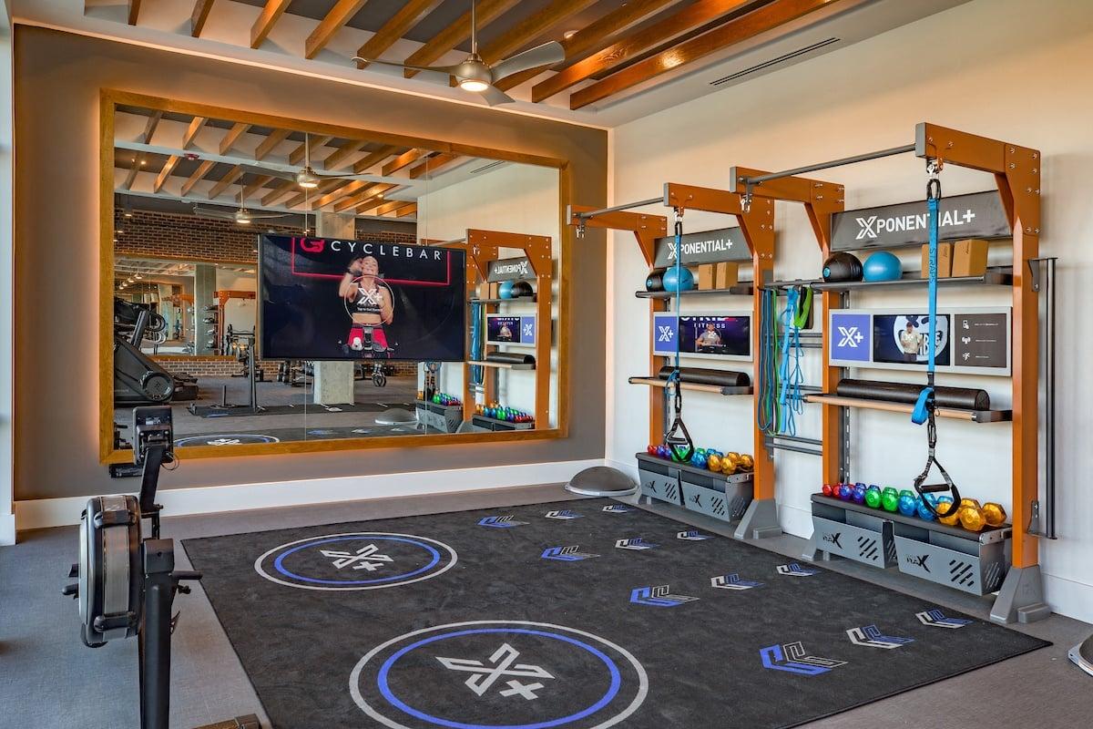 a home gym with a mirror and weights equipment and a tv