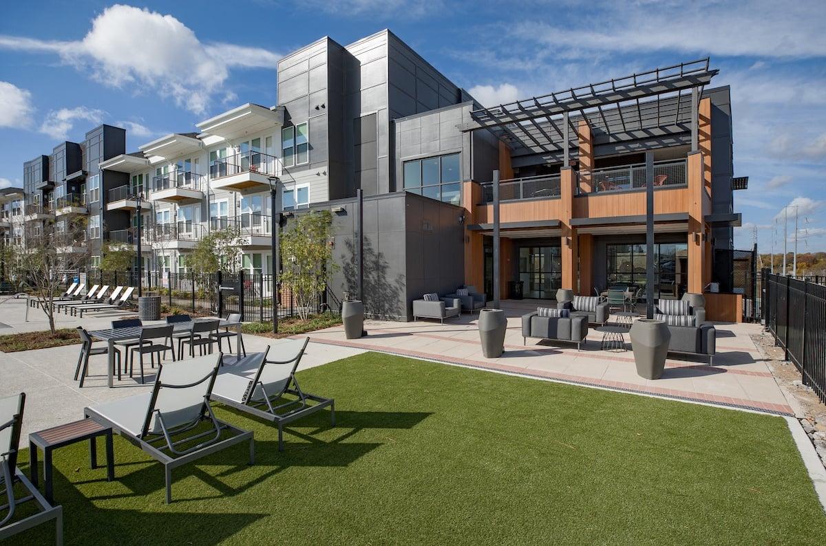 a rendering of a building with lawn chairs and tables