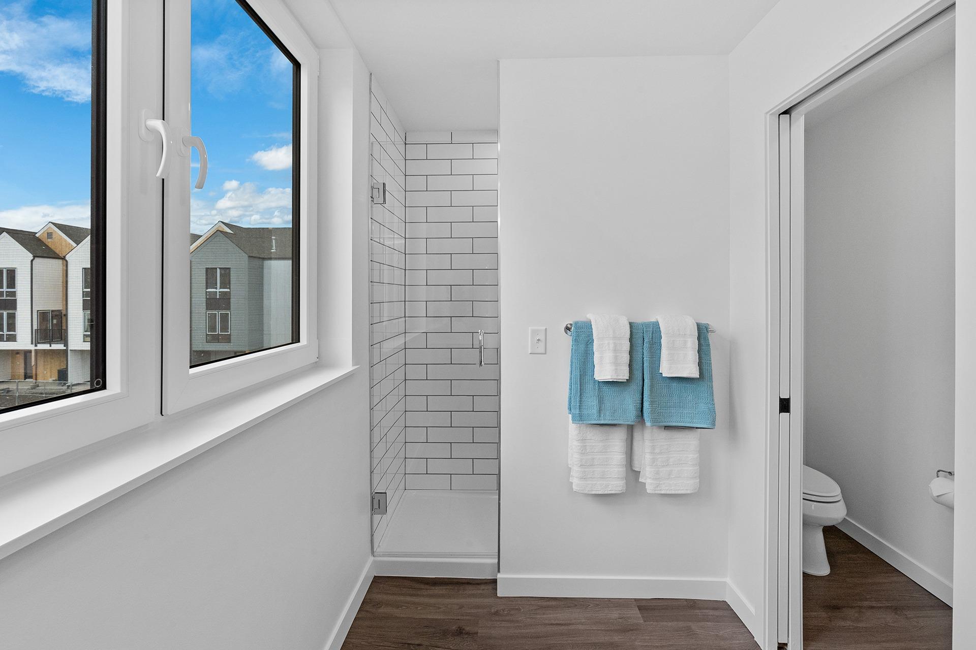 A bathroom with a towel rack holding two towels.