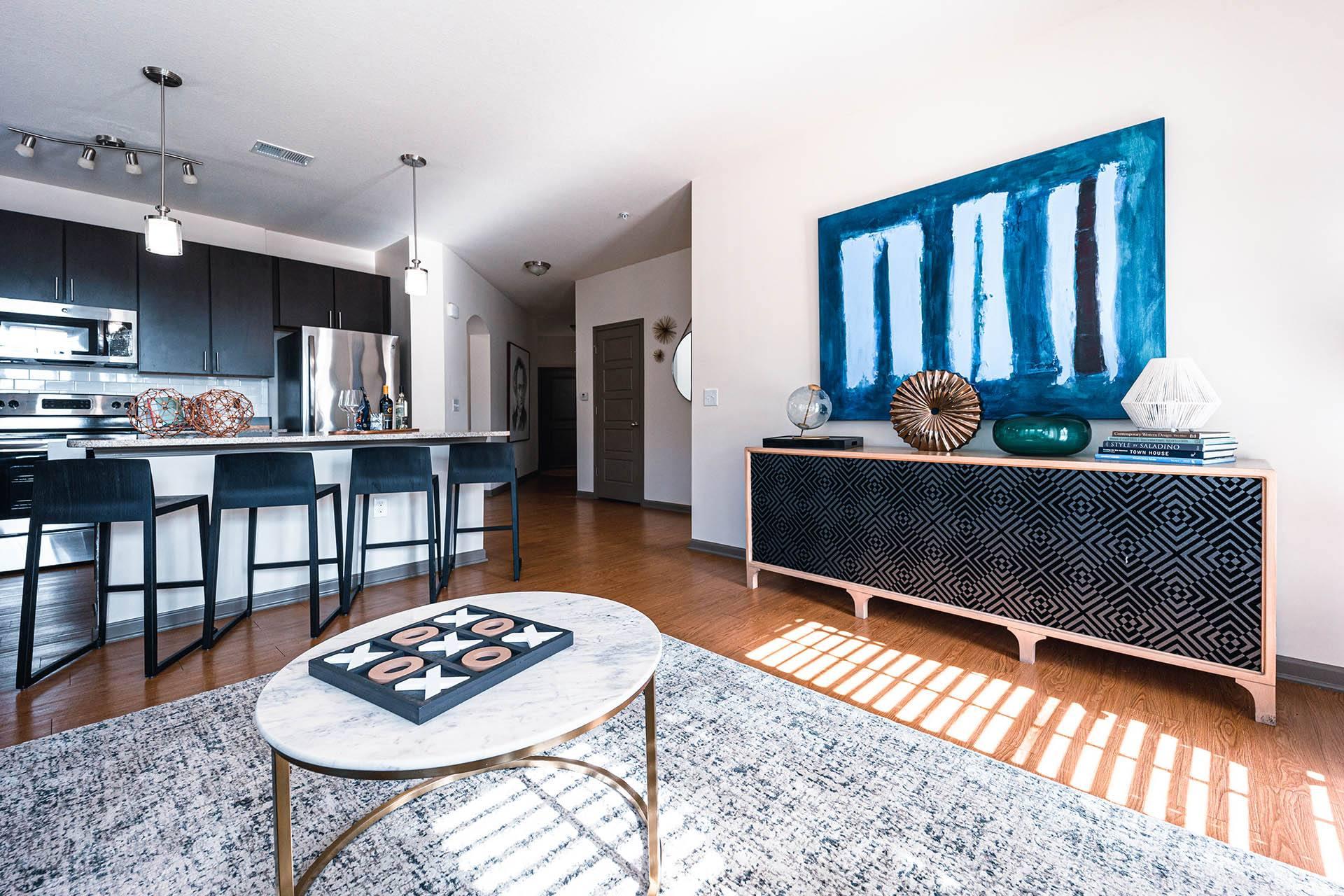 a living room with a large blue painting on the wall and a coffee table in the middle