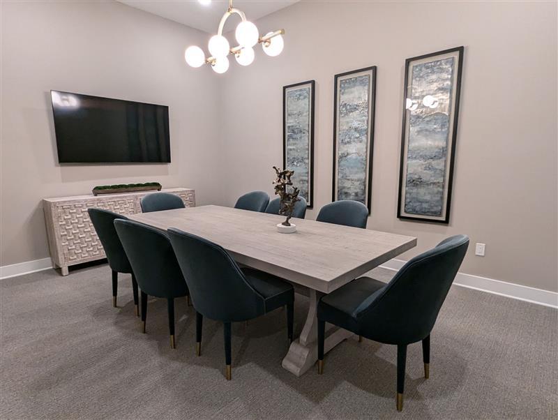 A dining room with a large table and chairs.