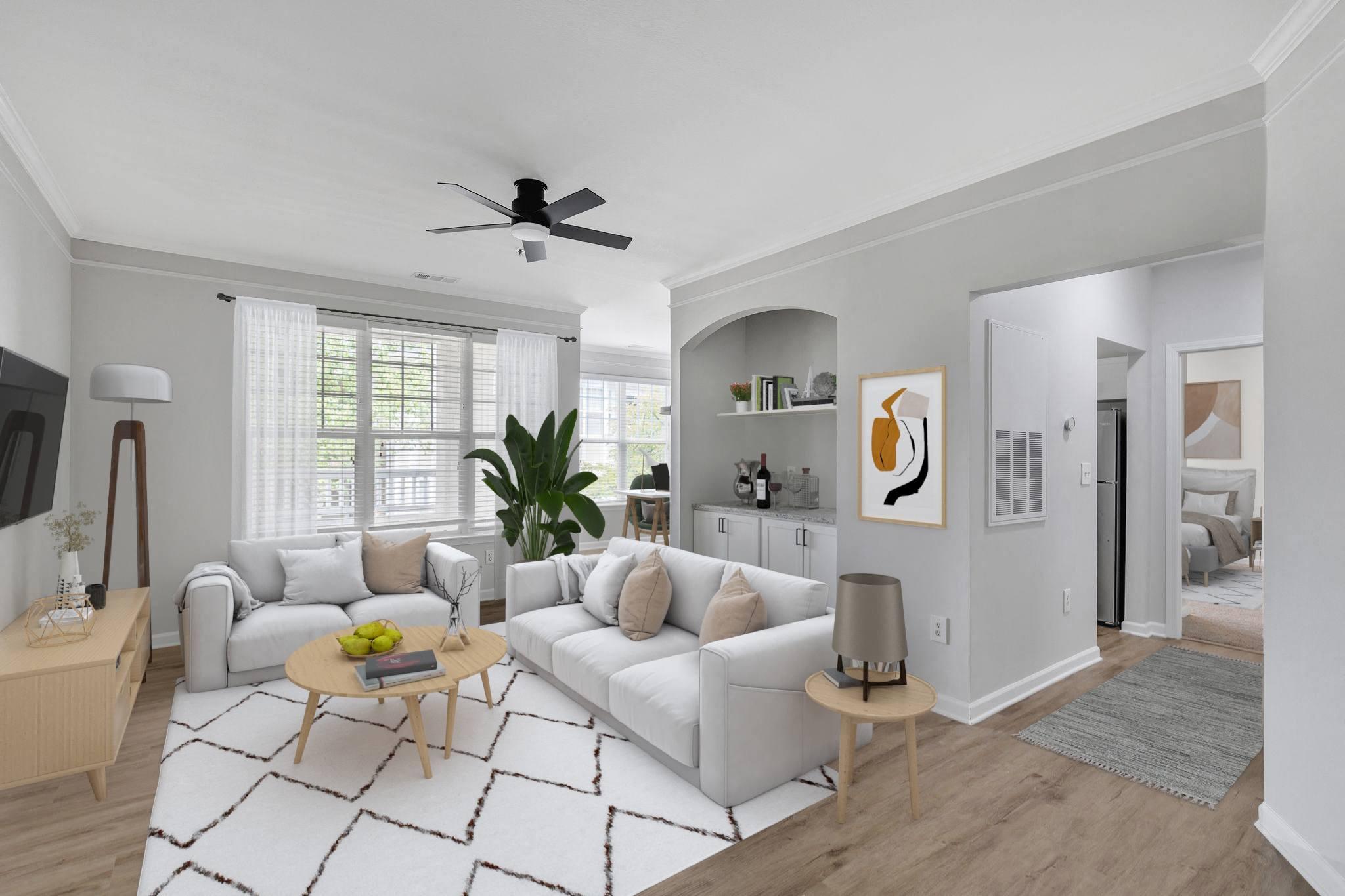A living room with a white couch, a wooden coffee table, and a ceiling fan.
