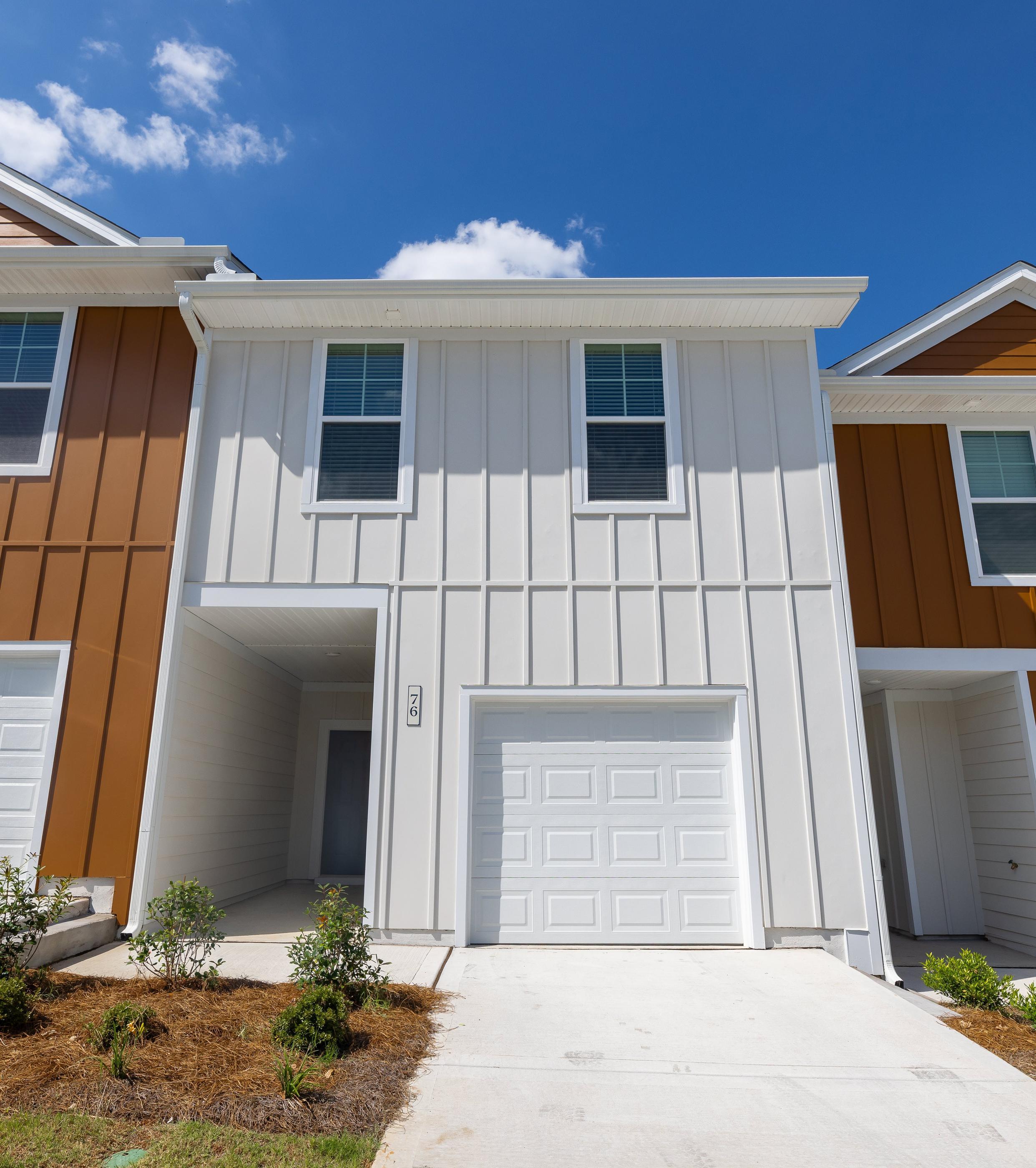 A modern house with a white garage door and brown sidings.
