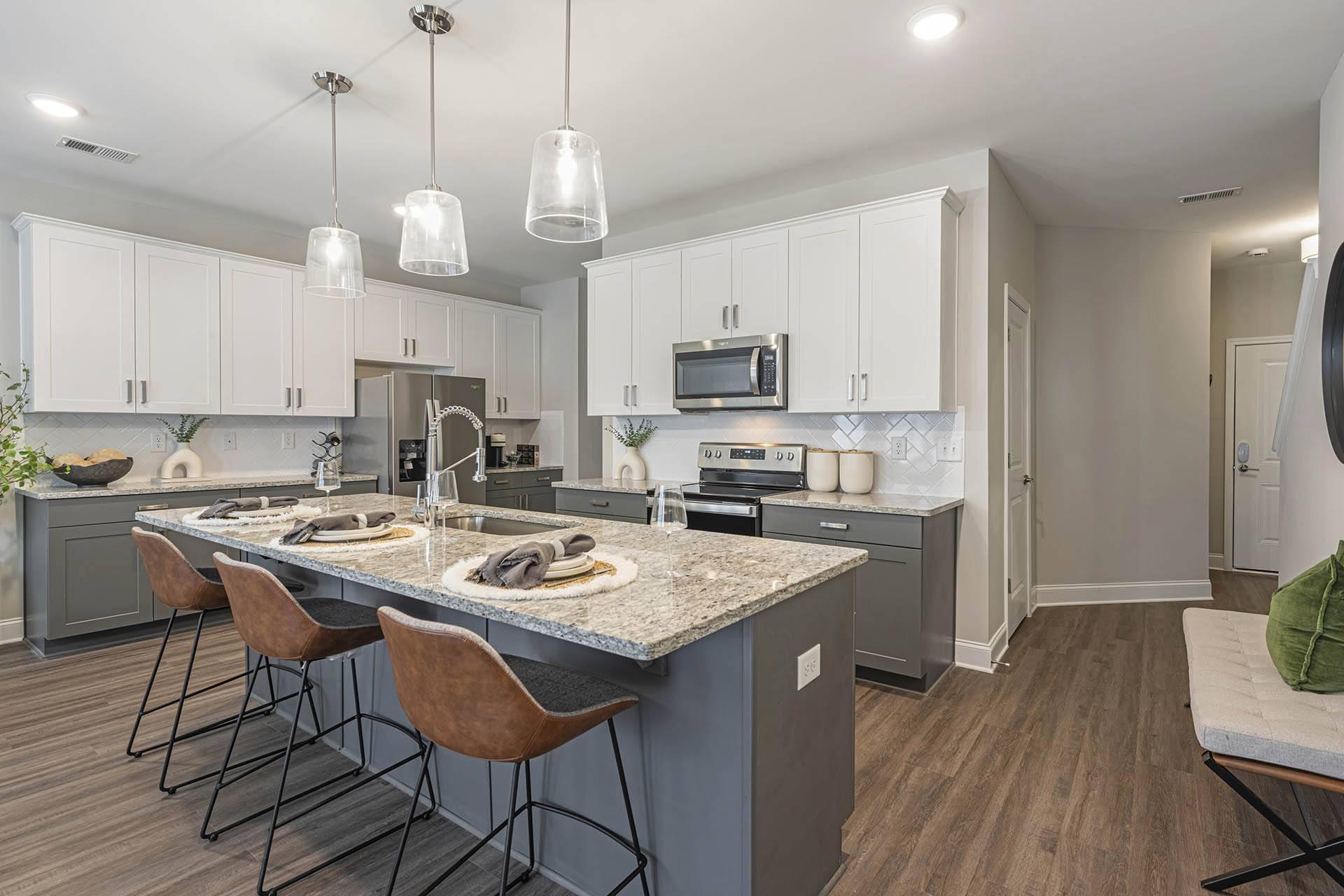 A kitchen with a large island and bar stools.