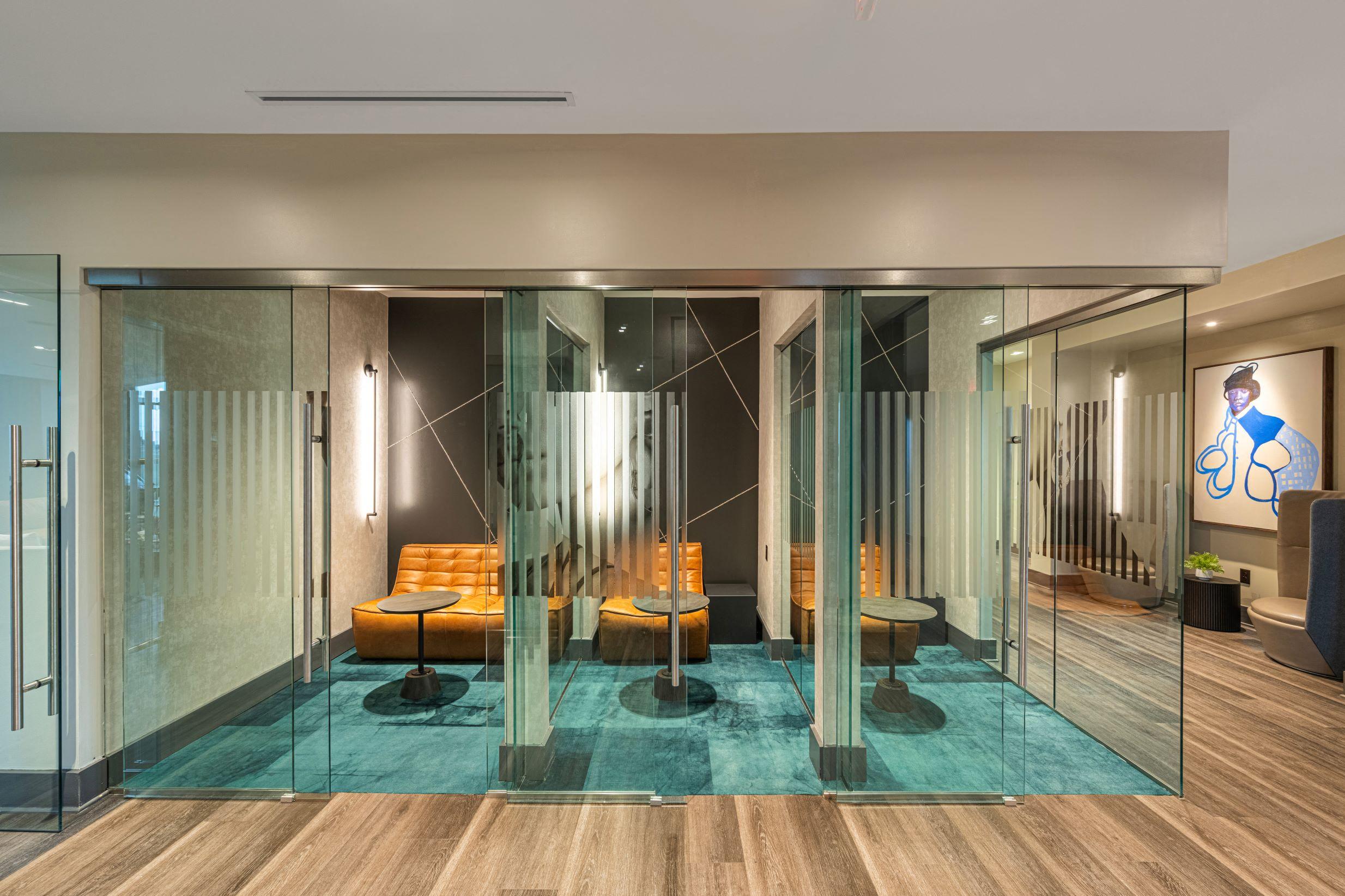 a room with glass walls and furniture and a blue rug