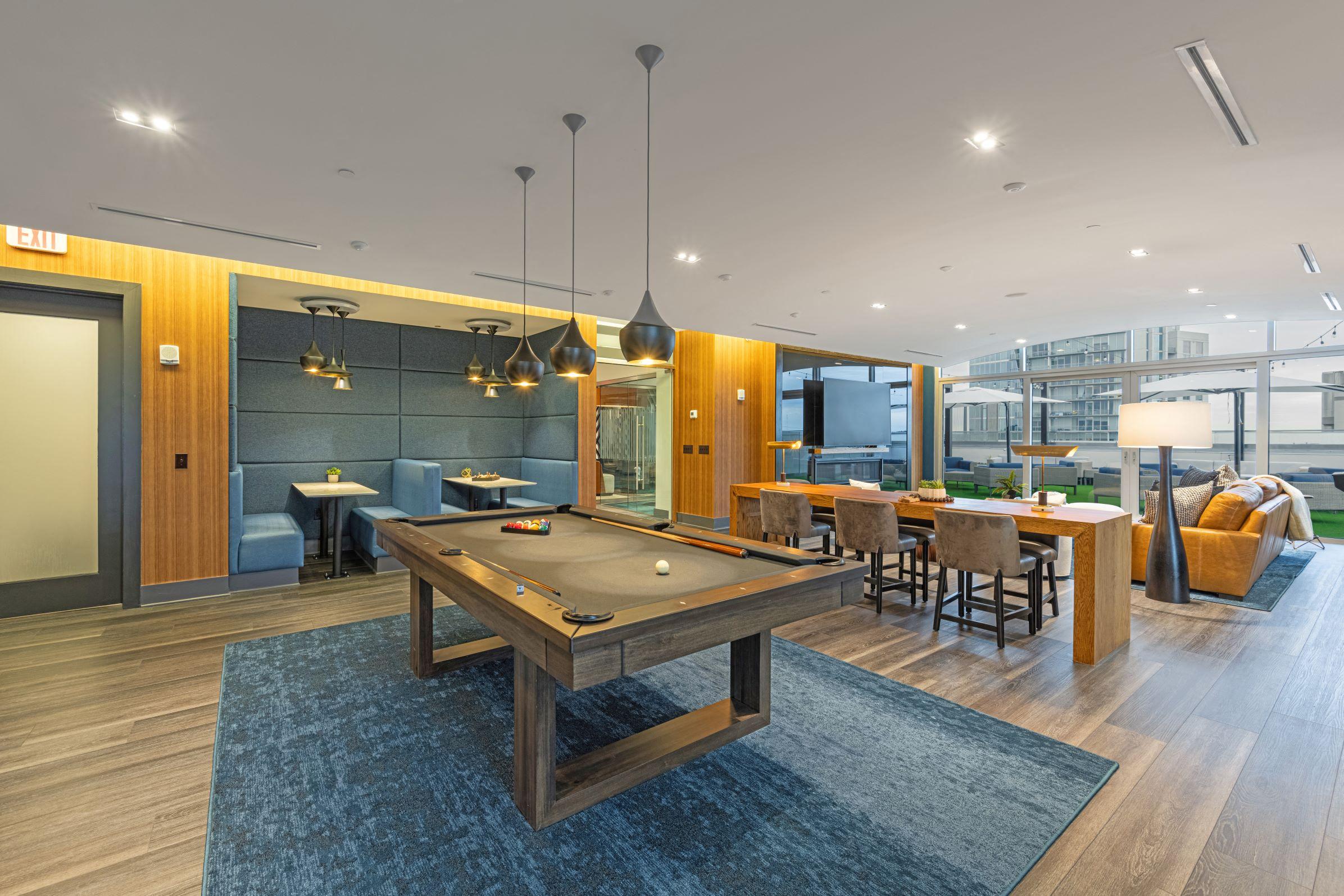 a pool table in a living room with tables and chairs