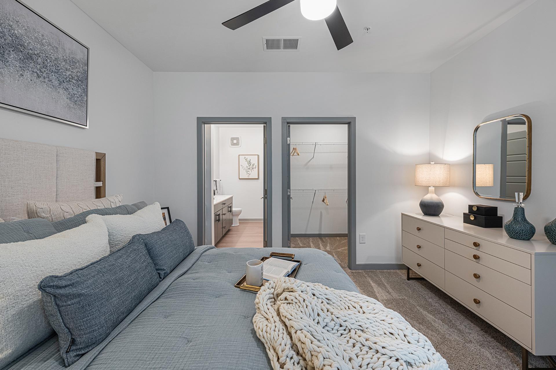 A bedroom with a bed, dresser, and mirror.