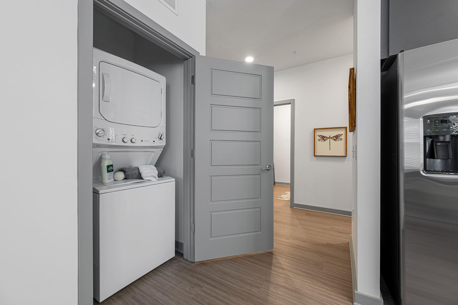 A modern kitchen with a white dishwasher and a grey door.