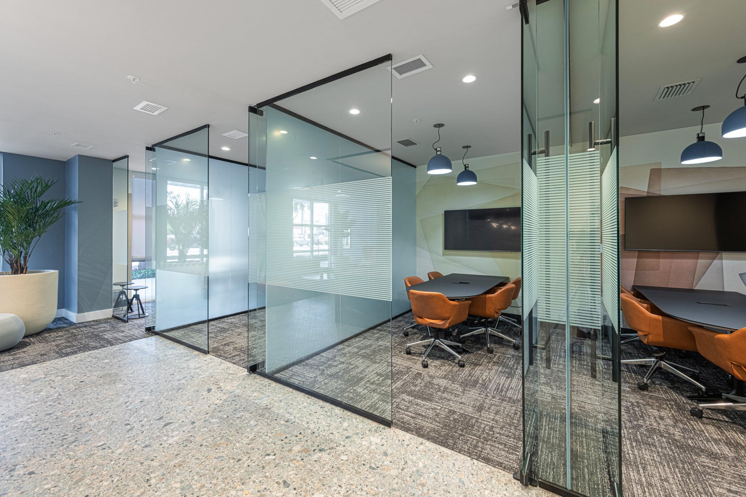 a conference room with glass walls and a table and chairs