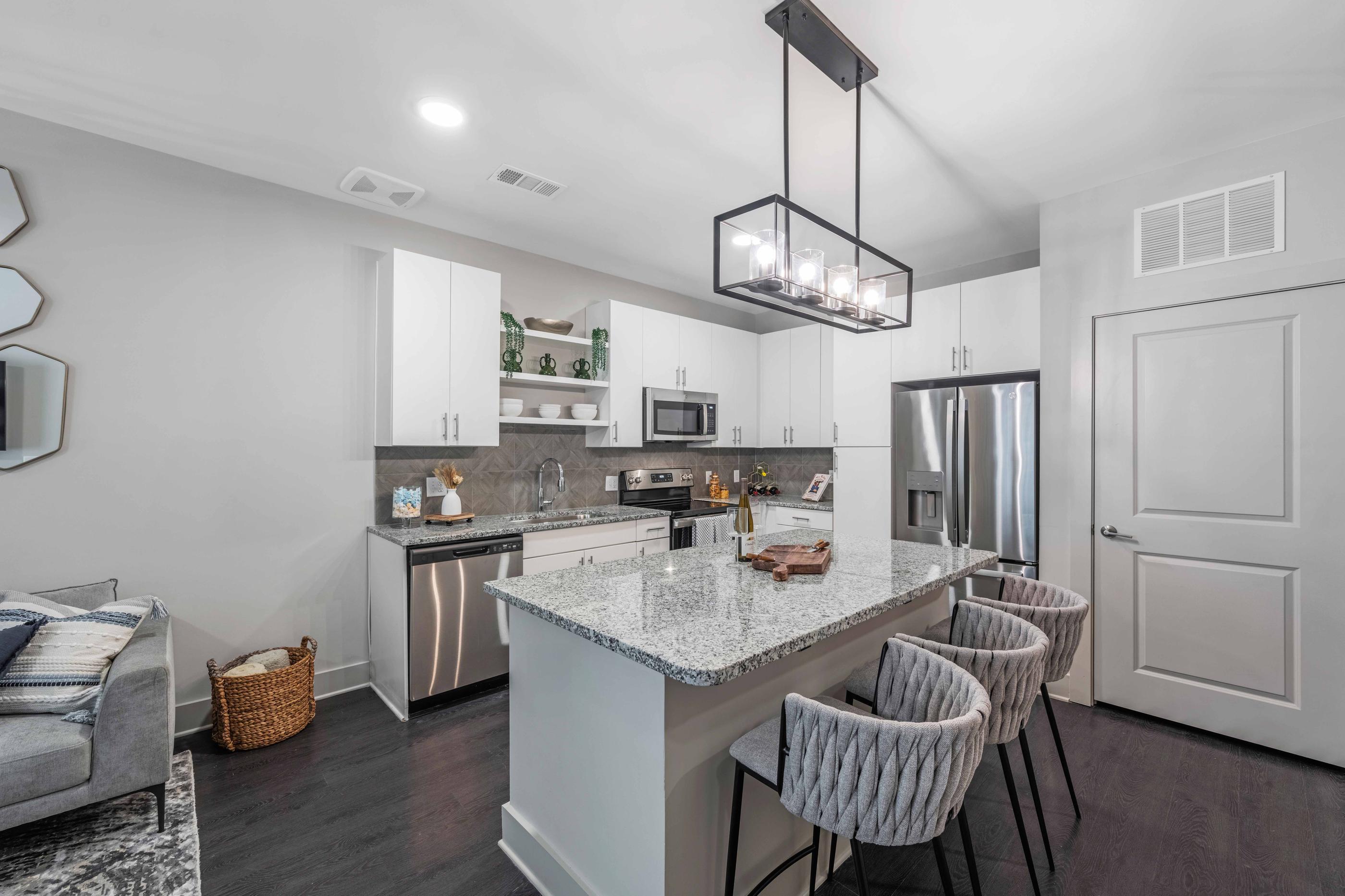 A modern kitchen with a large island and a dining area.