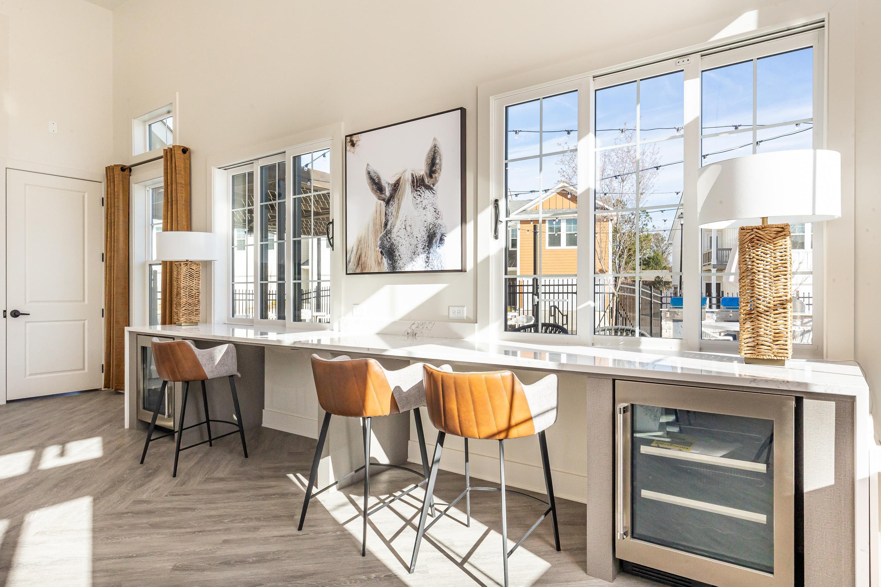 A kitchen with a table and chairs and a framed picture of a horse on the wall.