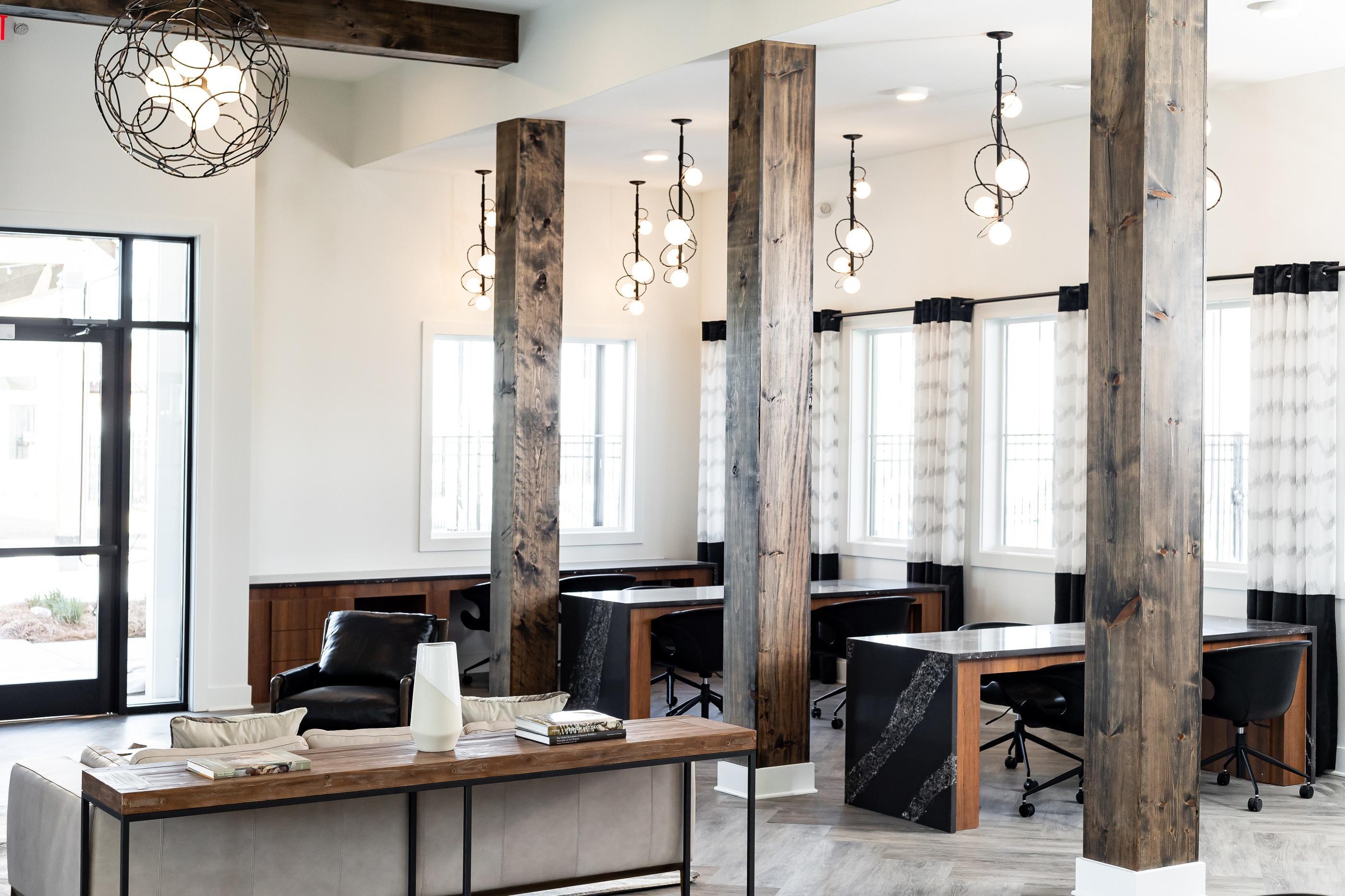 A modern office space with wooden pillars and black chairs.