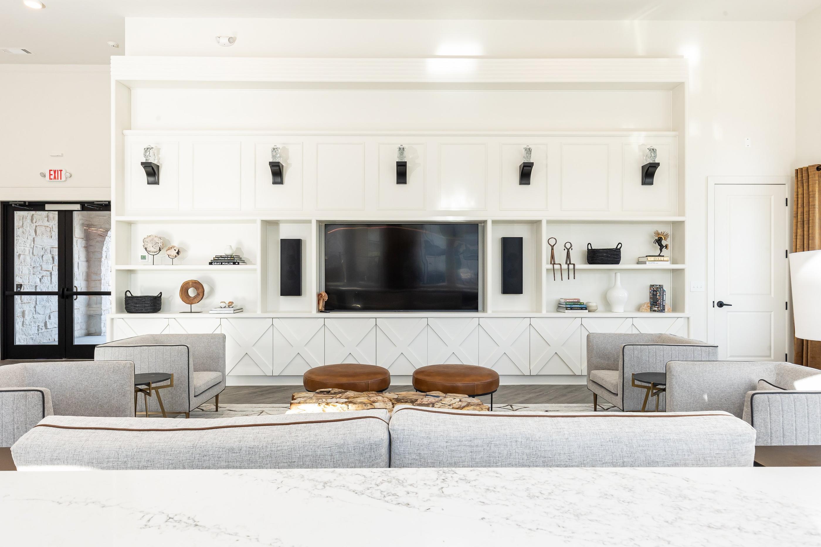 A living room with a grey sofa and a white wall.