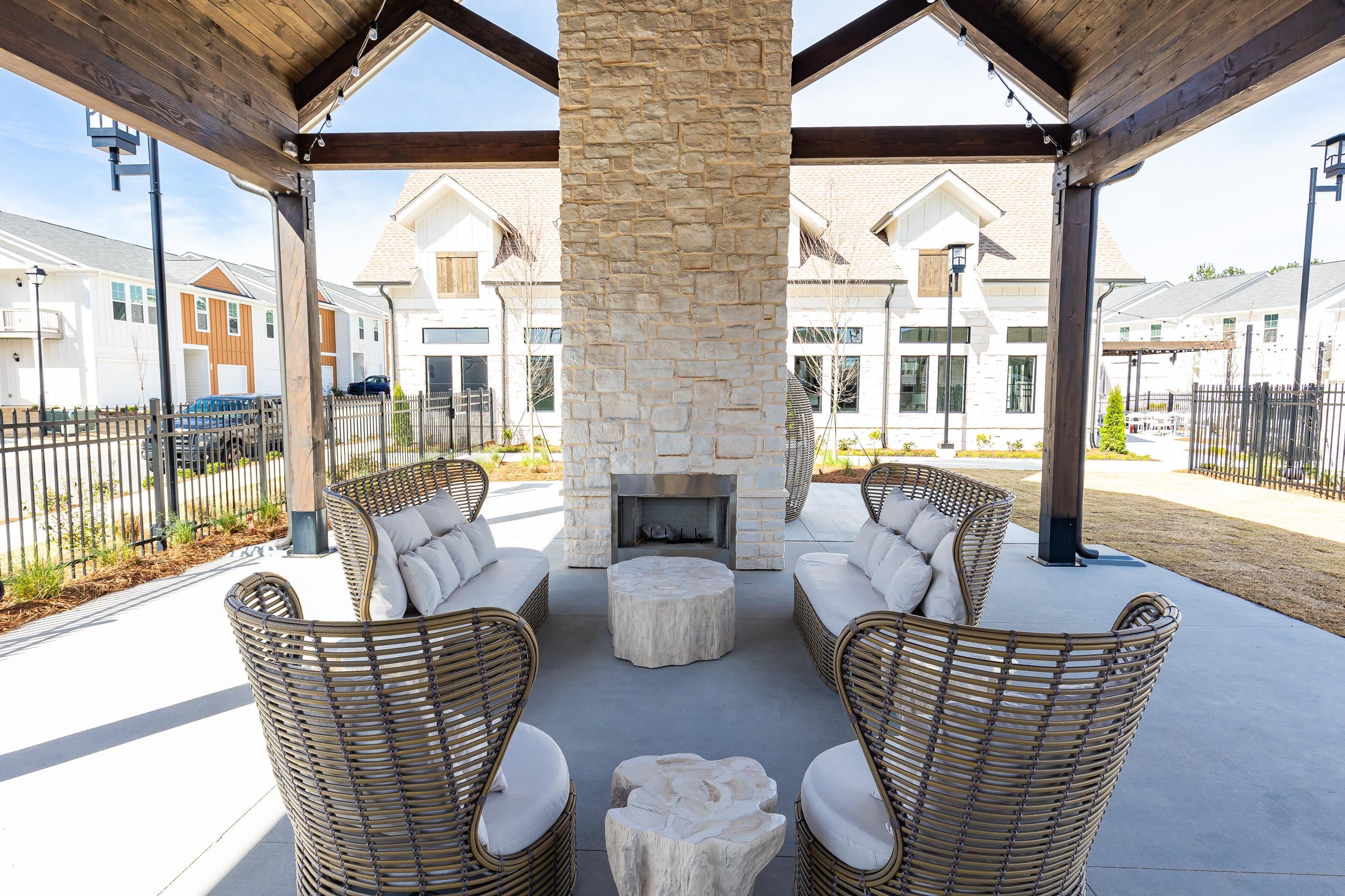 A patio with a fireplace and chairs.