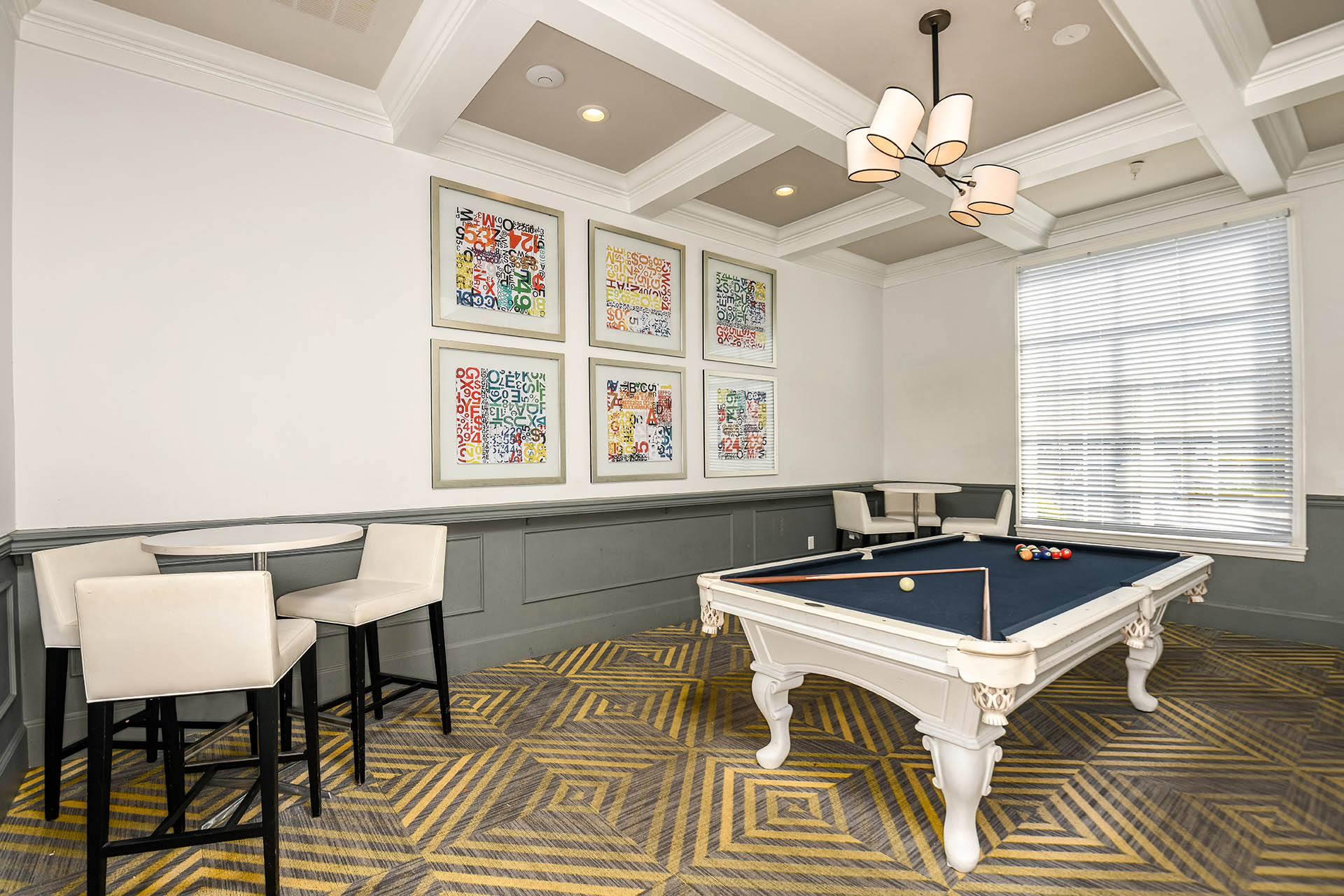 a games room with a pool table and chairs