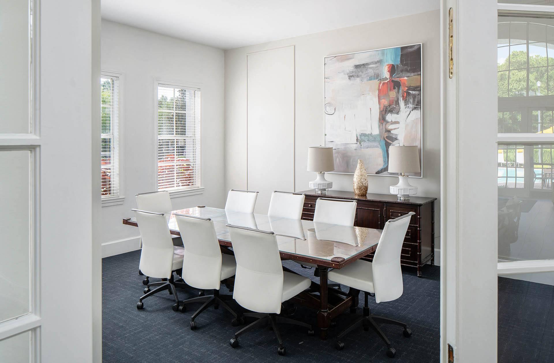 a dining room with a table and chairs and a painting on the wall