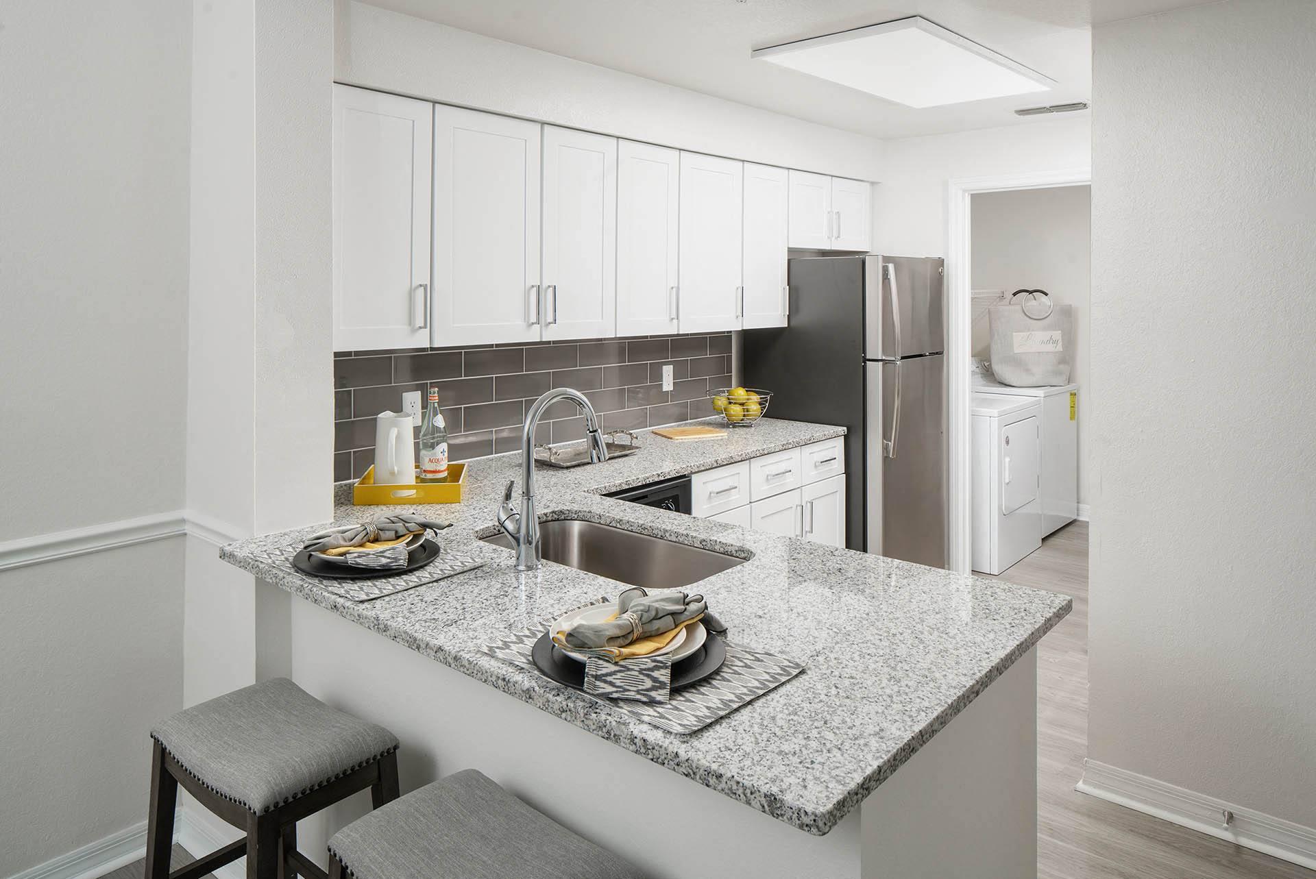 a kitchen with white cabinets and a granite counter top