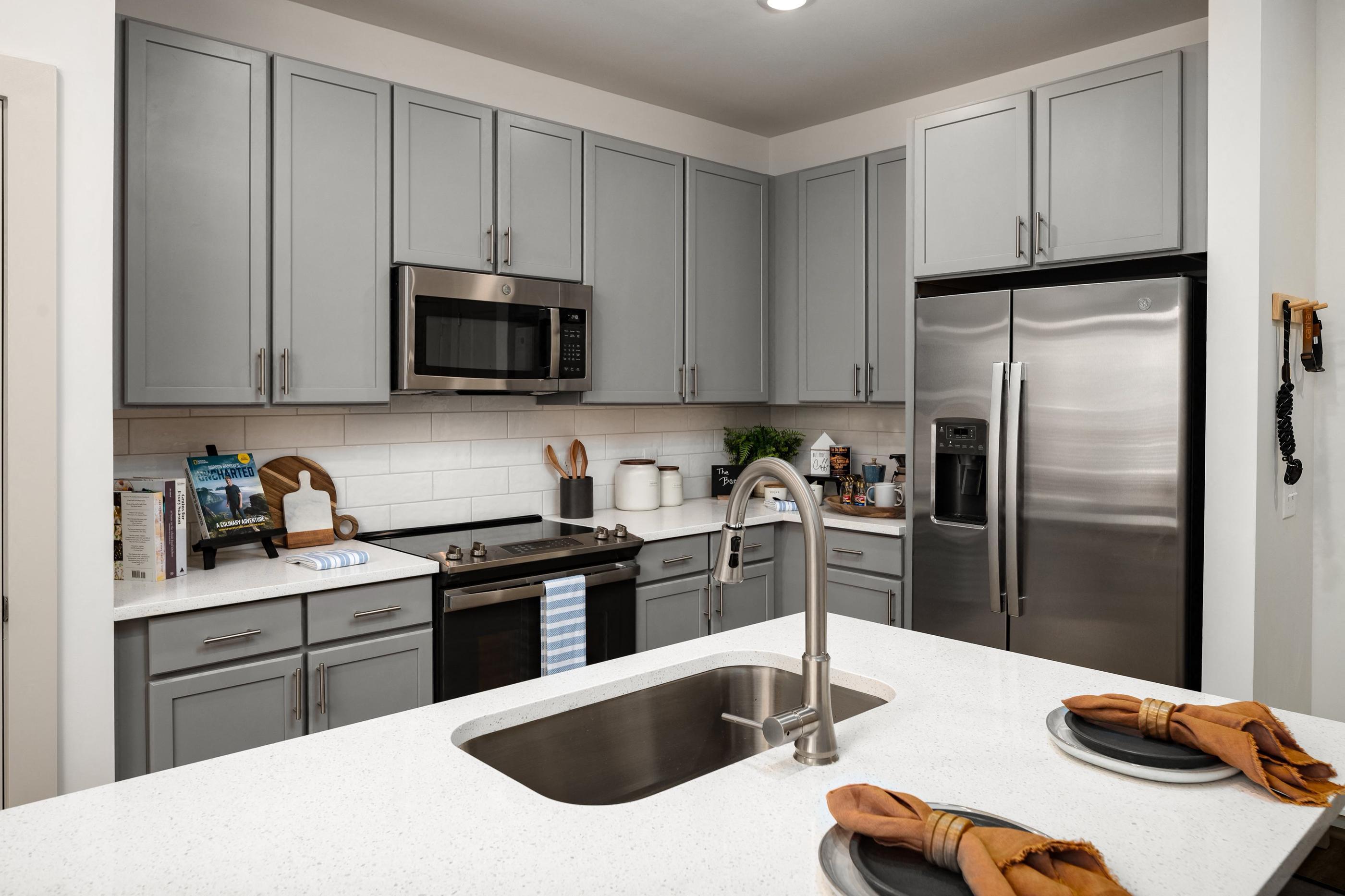 a kitchen with stainless steel appliances and gray cabinets