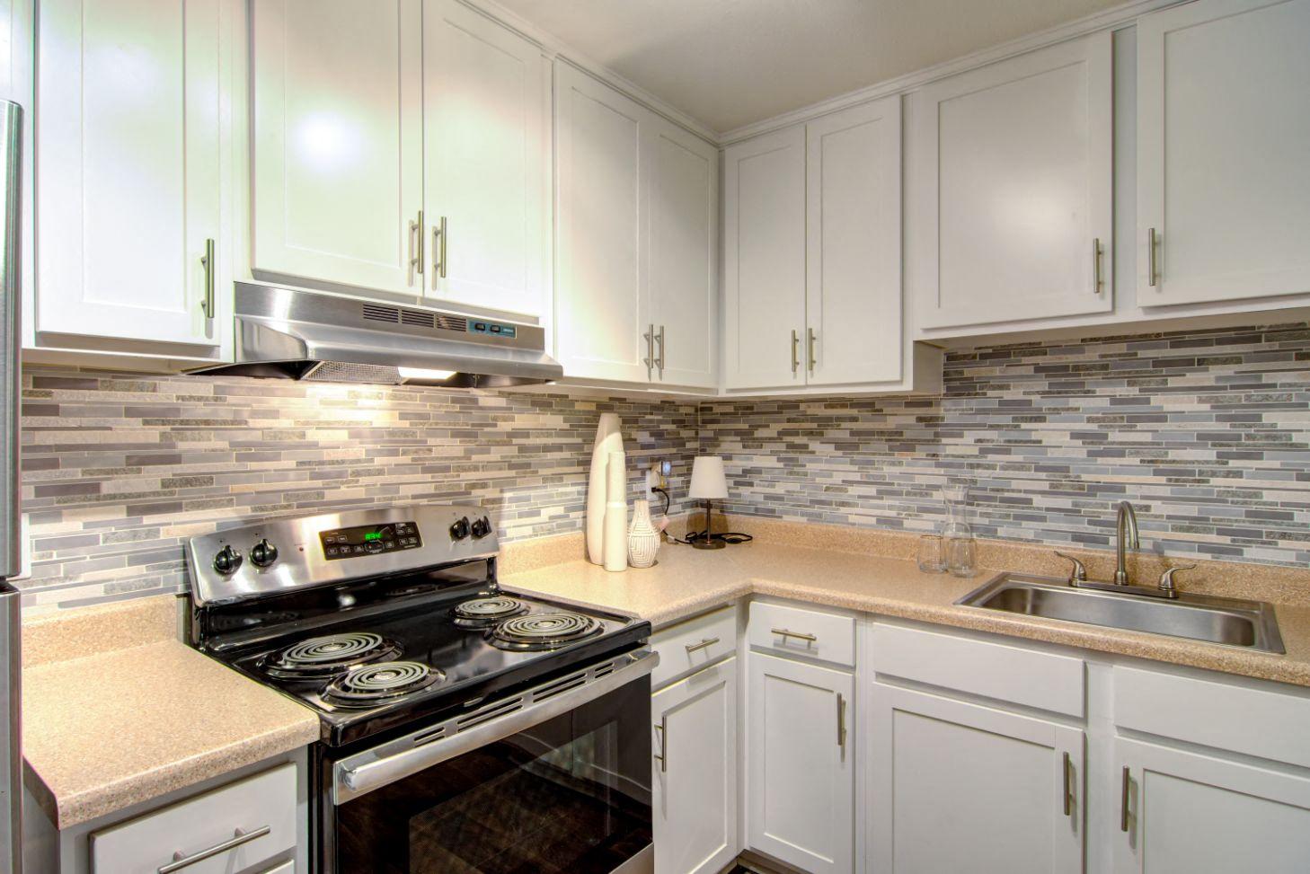 a kitchen with white cabinets and a black stove top oven