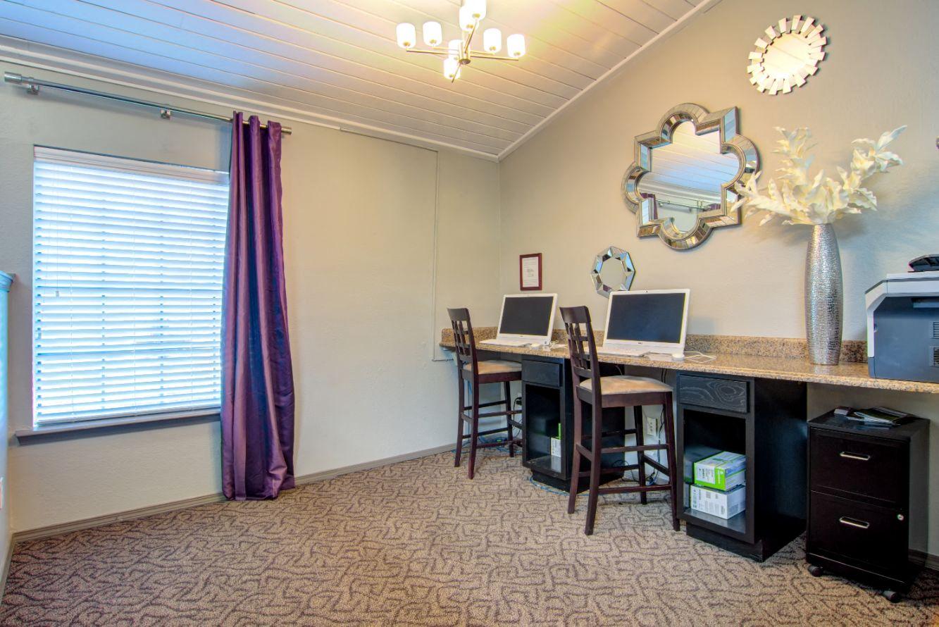 a home office with two computers and a printer