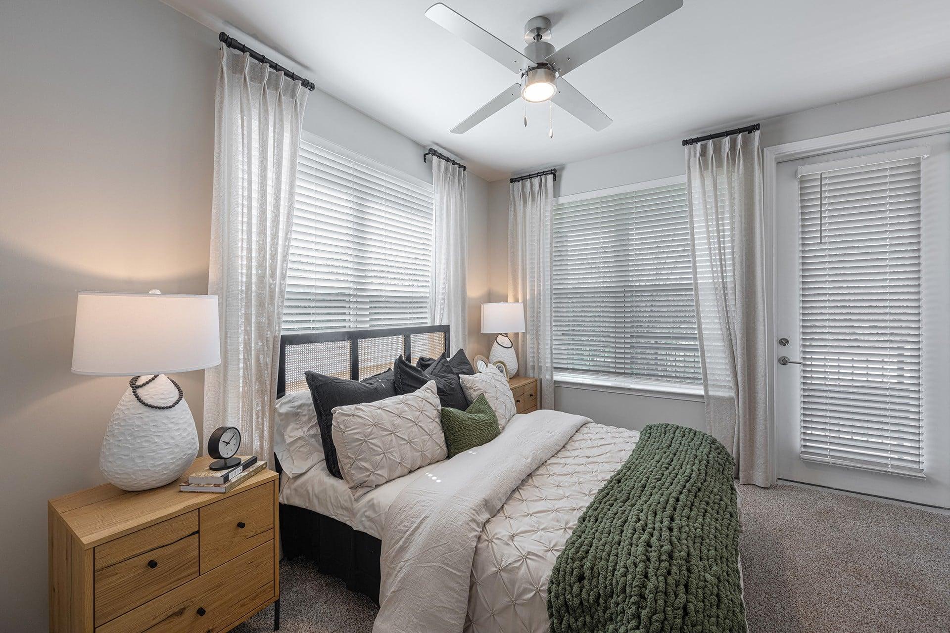a bedroom with a large bed and a ceiling fan