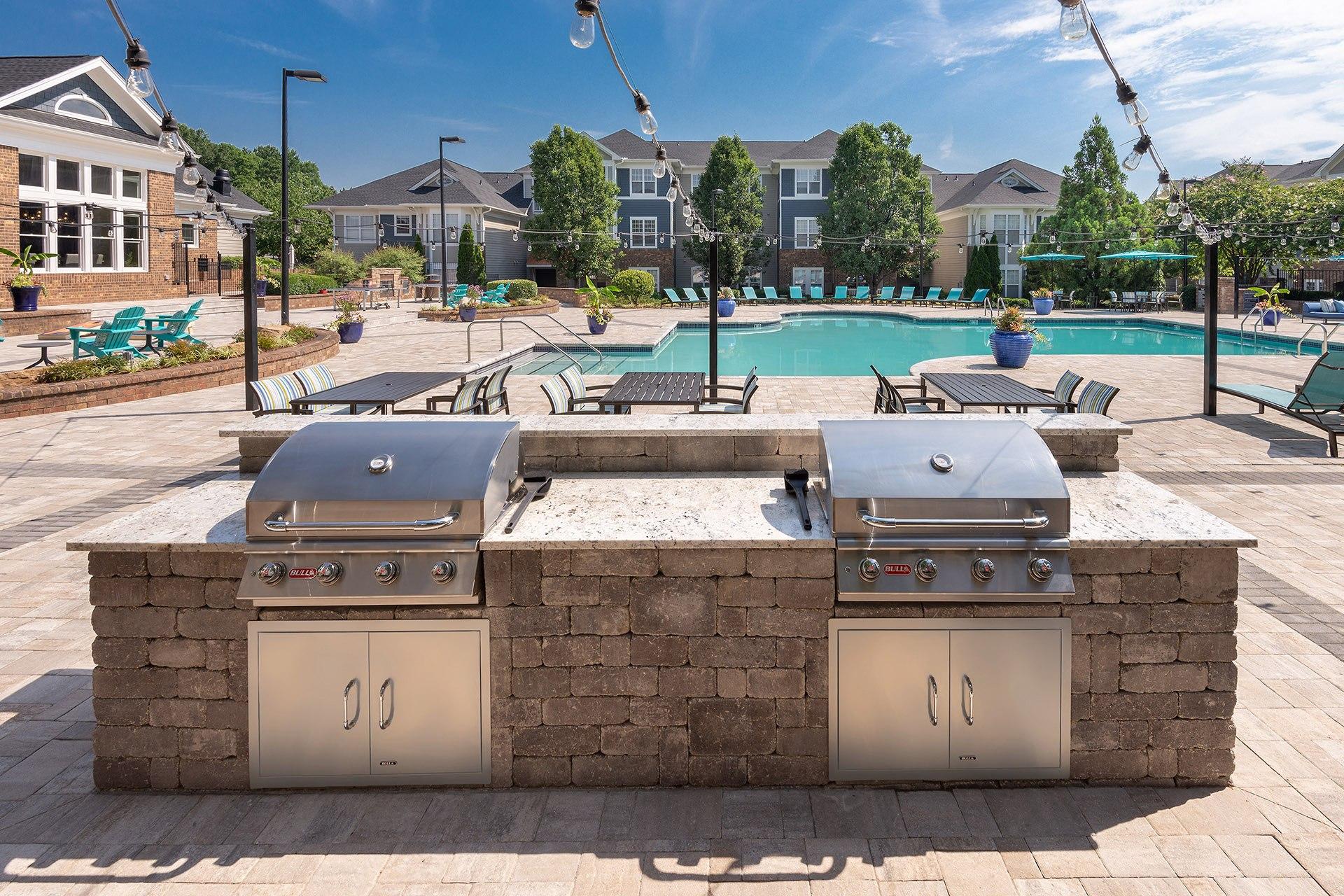 A BBQ grill is built into a brick wall.