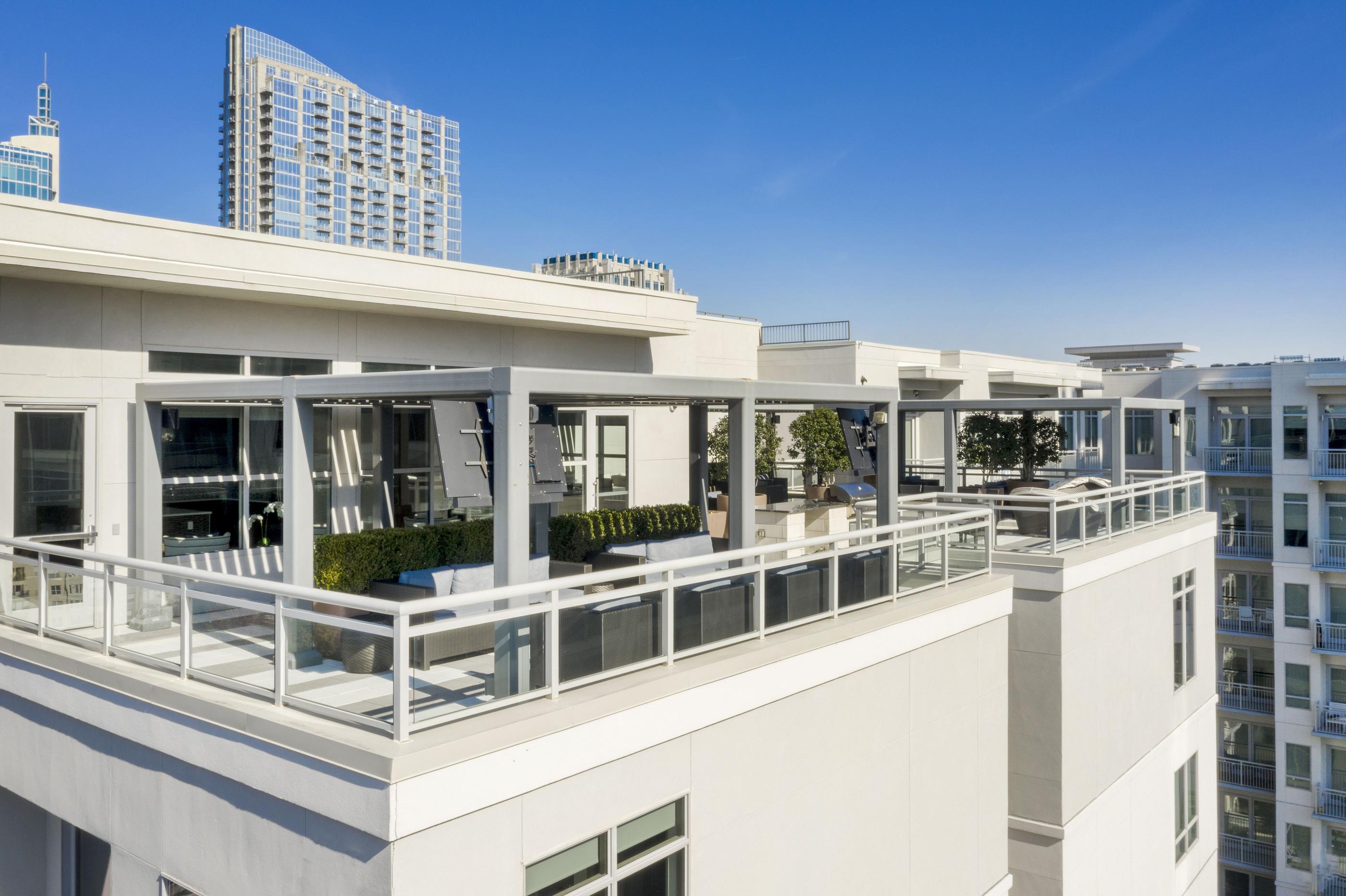 A white building with balconies overlooks a cityscape.