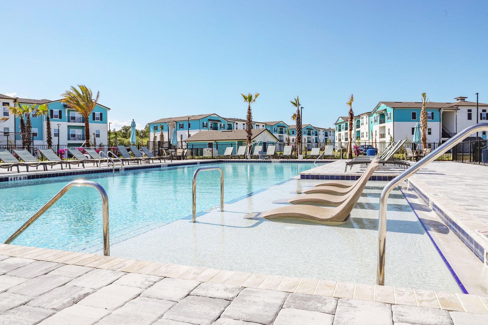 a swimming pool with a slide in front of some apartments