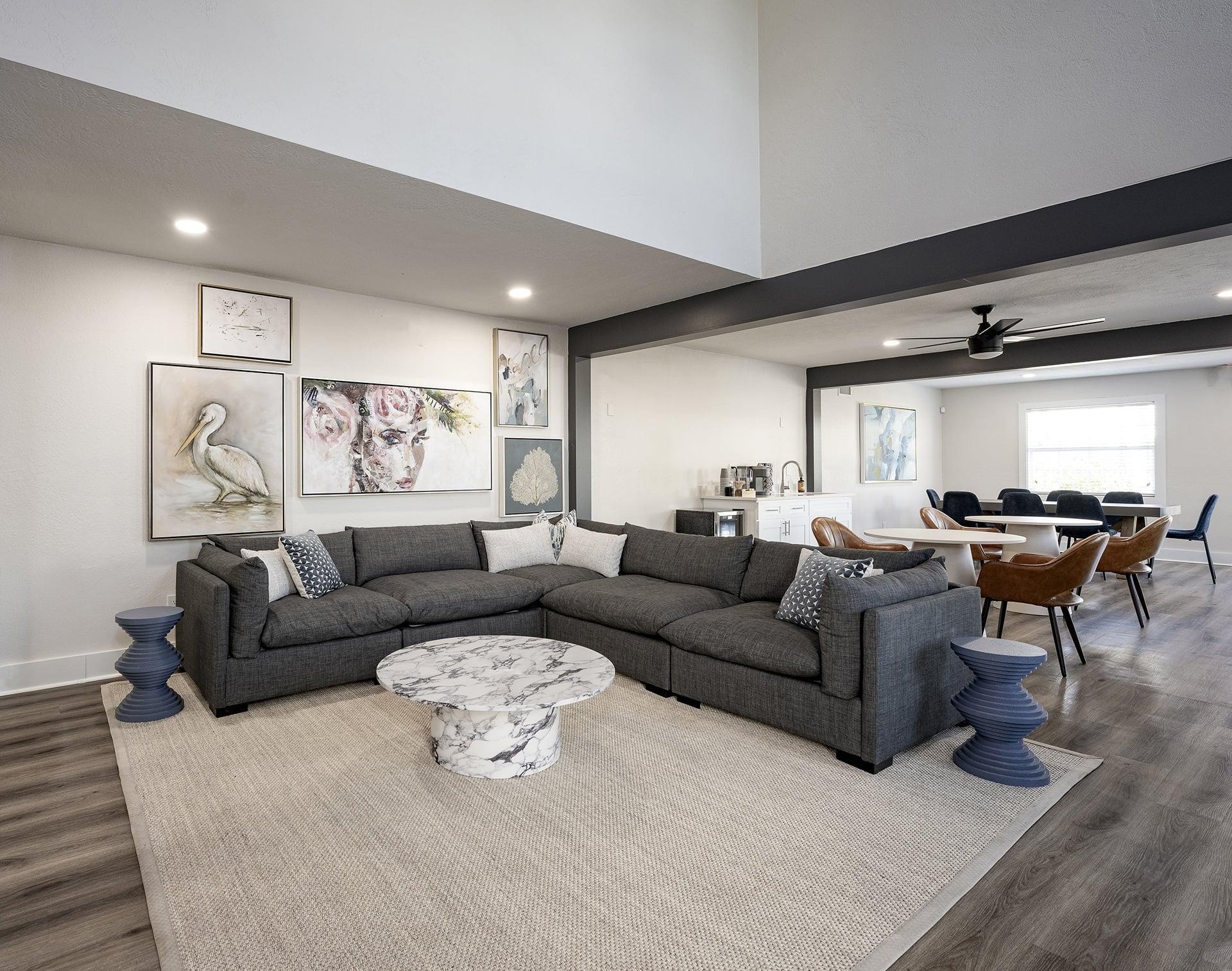 A living room with a grey sofa and a round marble table.