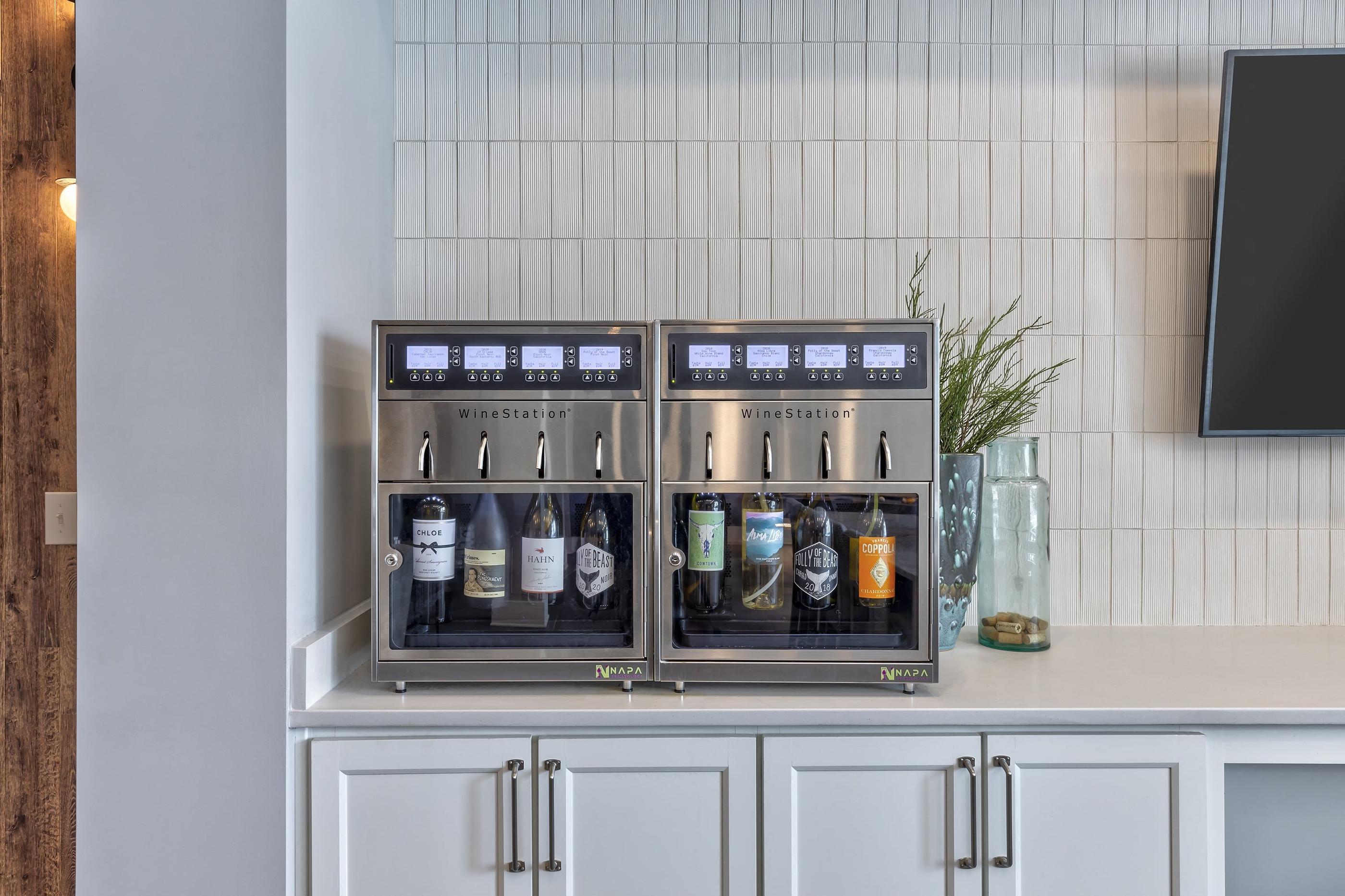 a kitchen with two refrigerators with bottles of alcohol on it