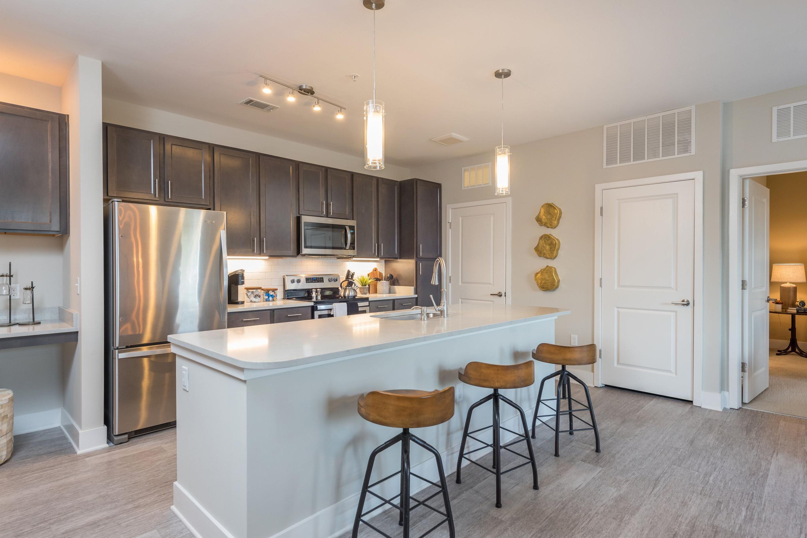 A kitchen with a white island and stools.