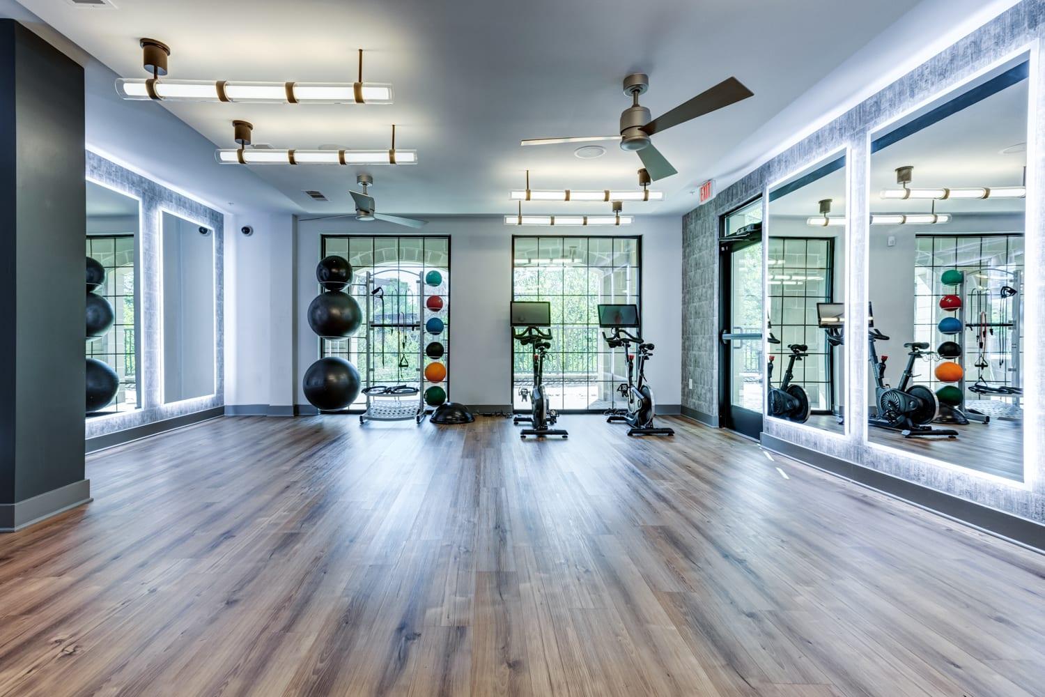 A gym with a variety of equipment including a rowing machine, a stationary bike, and a treadmill.
