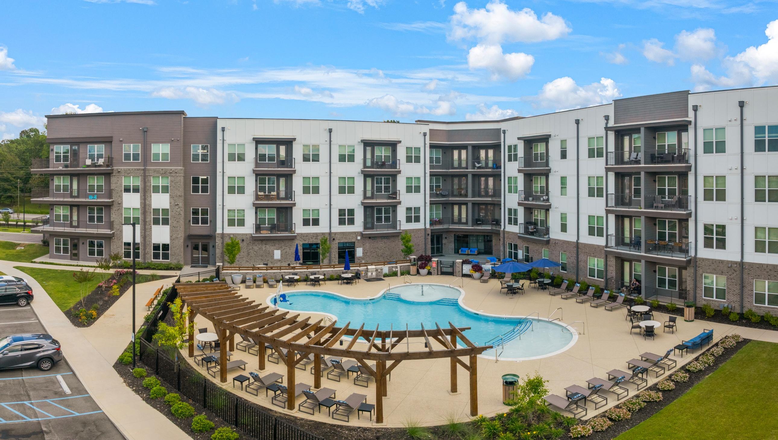 A large apartment complex with a pool and a deck.