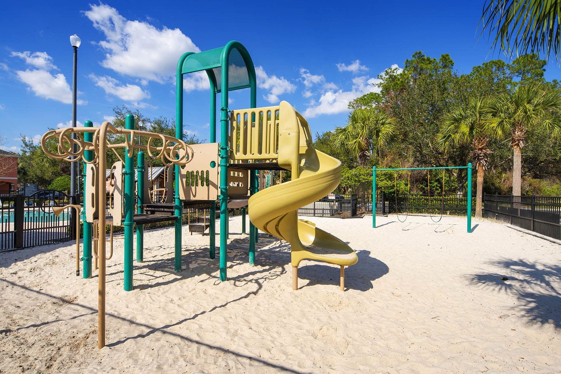 a playground with a large yellow slide in a park