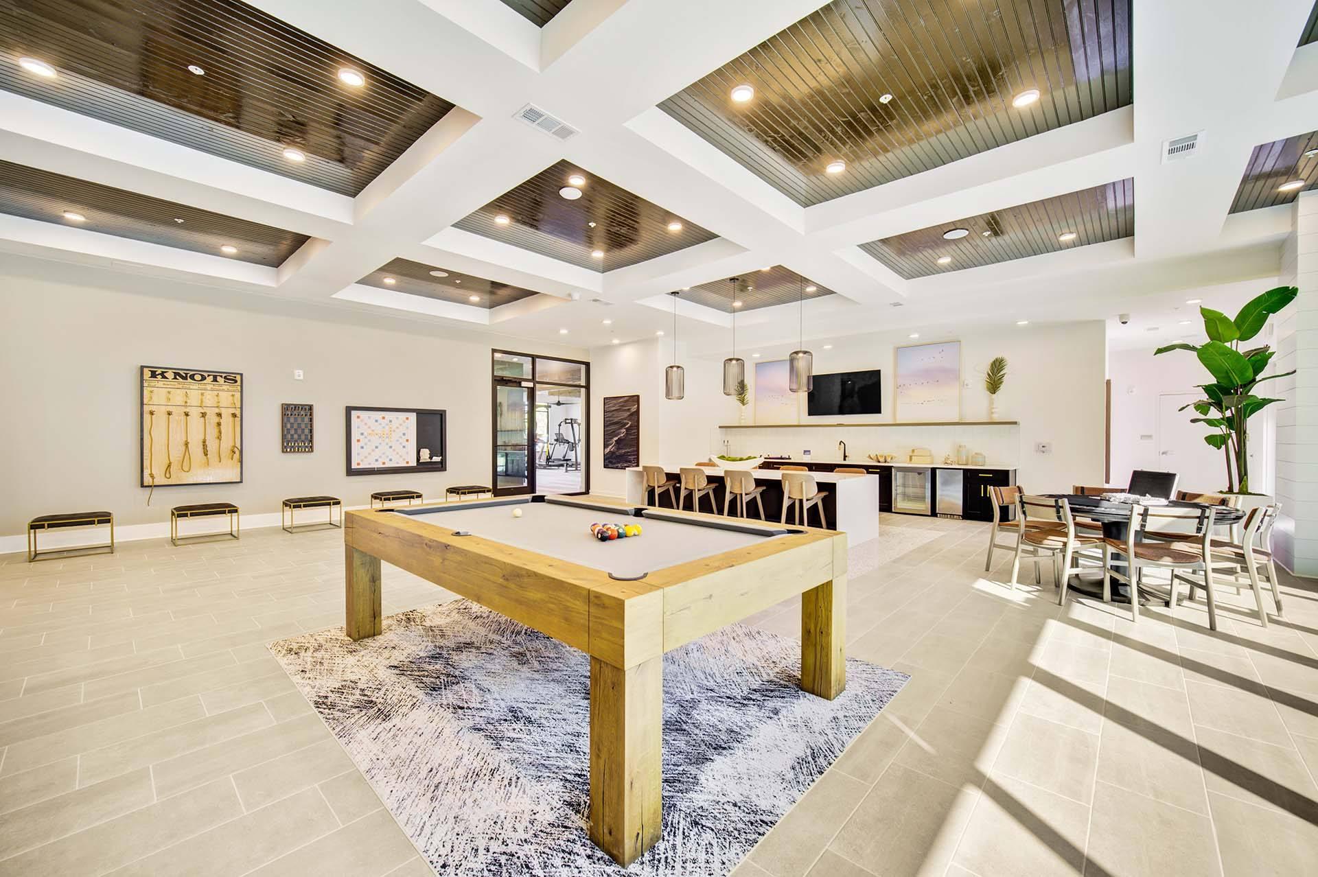 A large room with a pool table in the center.