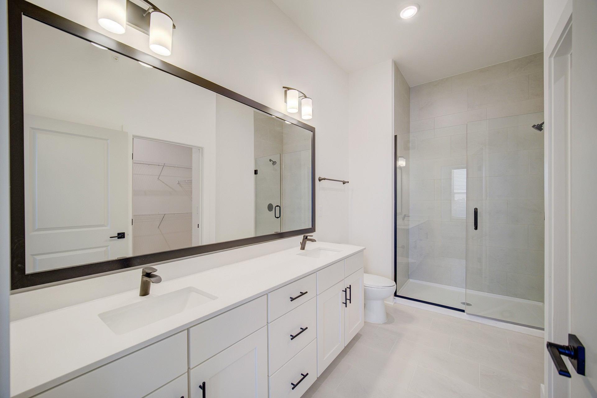 A bathroom with a white sink and a large mirror.