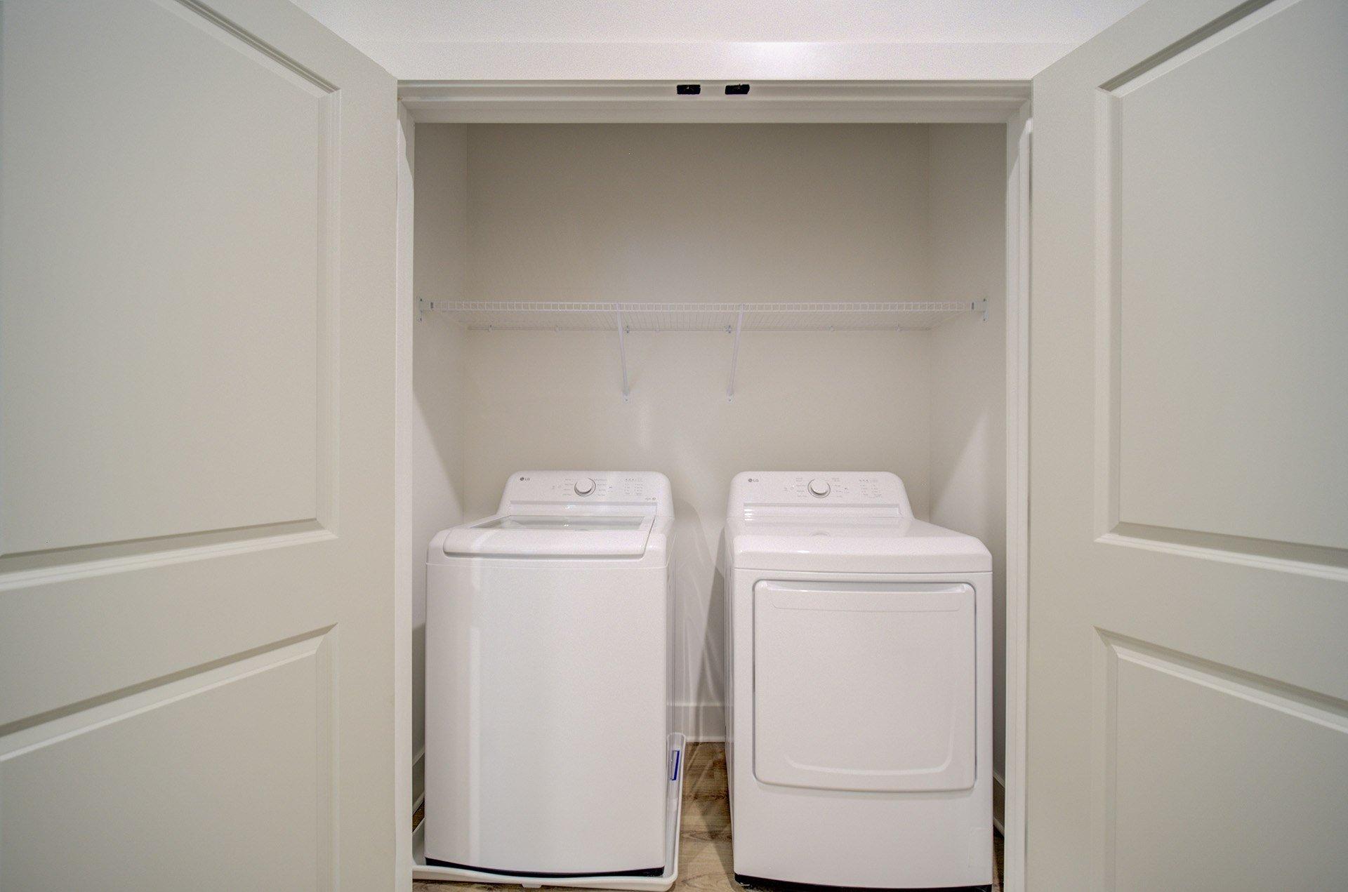 Two white front loading washing machines in a laundry room.