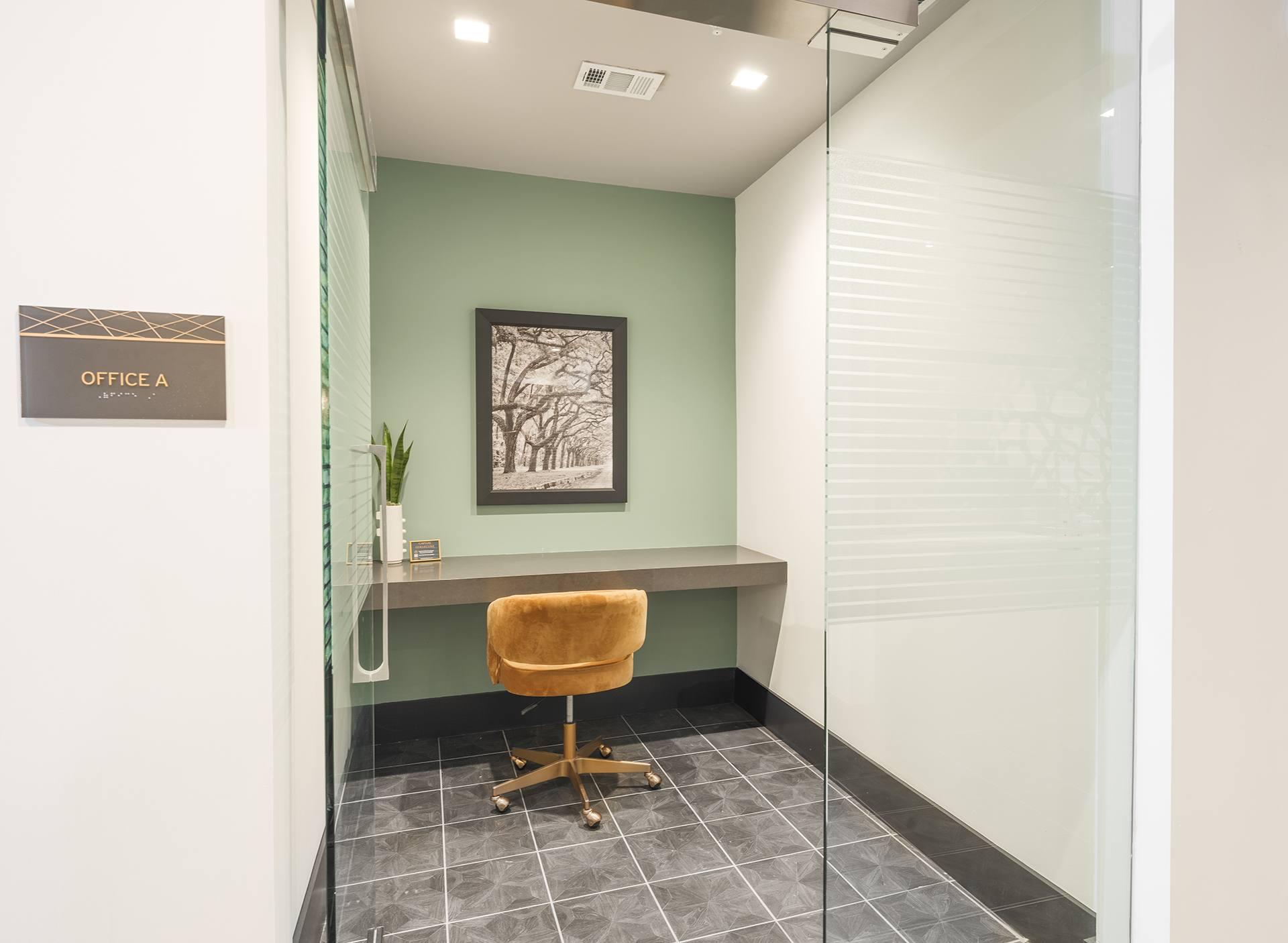 A glass wall separates the office from the hallway.