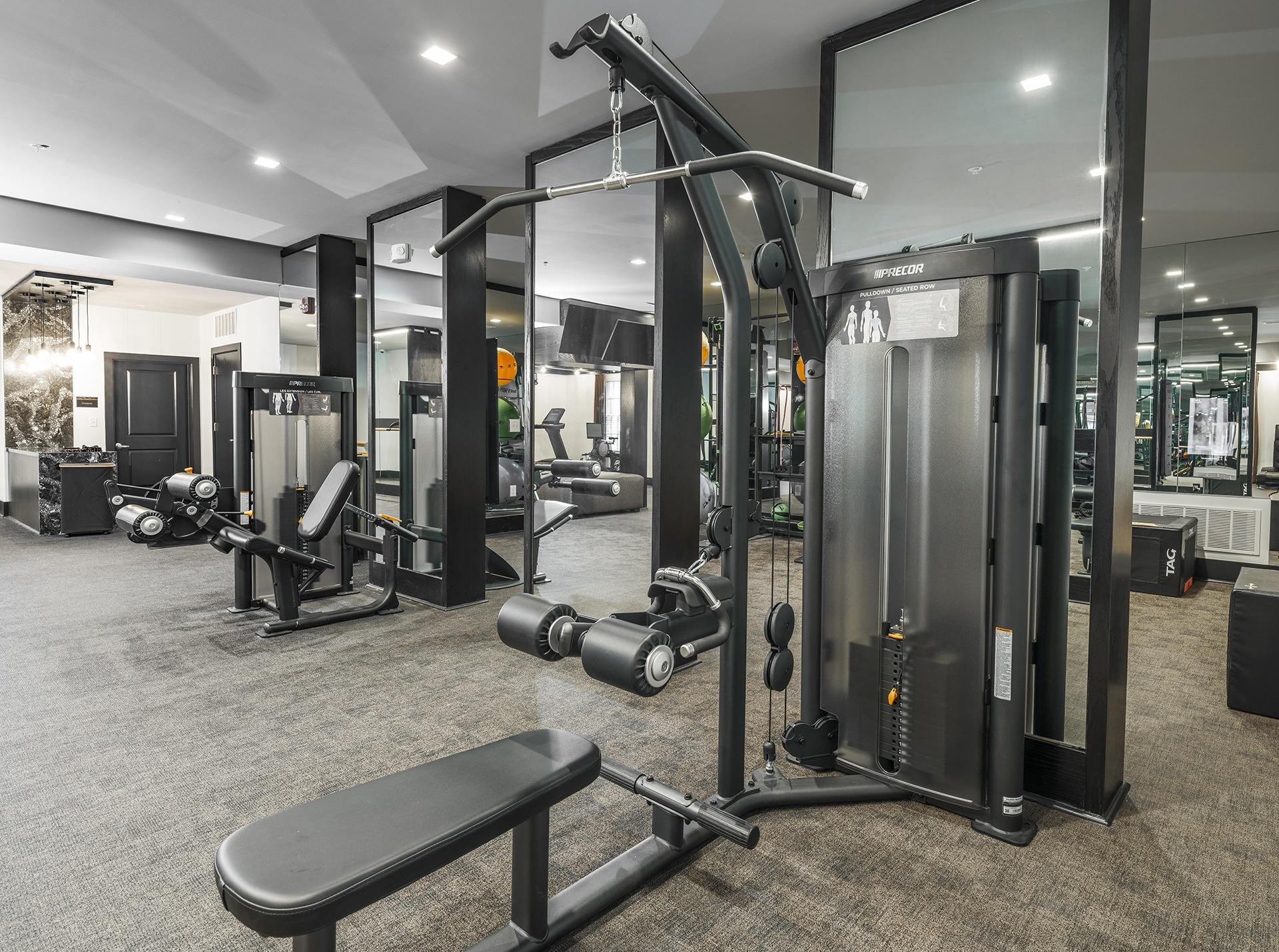 A gym with a variety of equipment including a leg press machine.