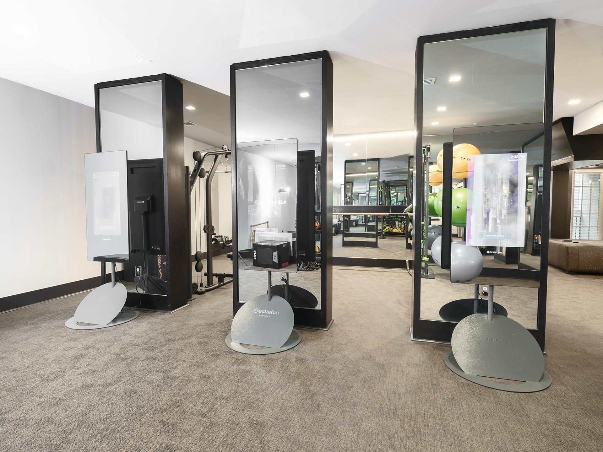 Three mirrors are on stands in a room.