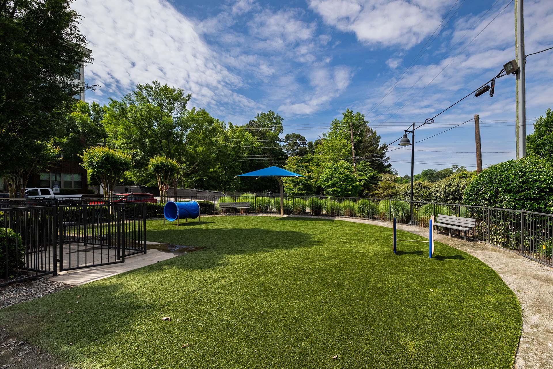 A park with a blue umbrella and a bench.