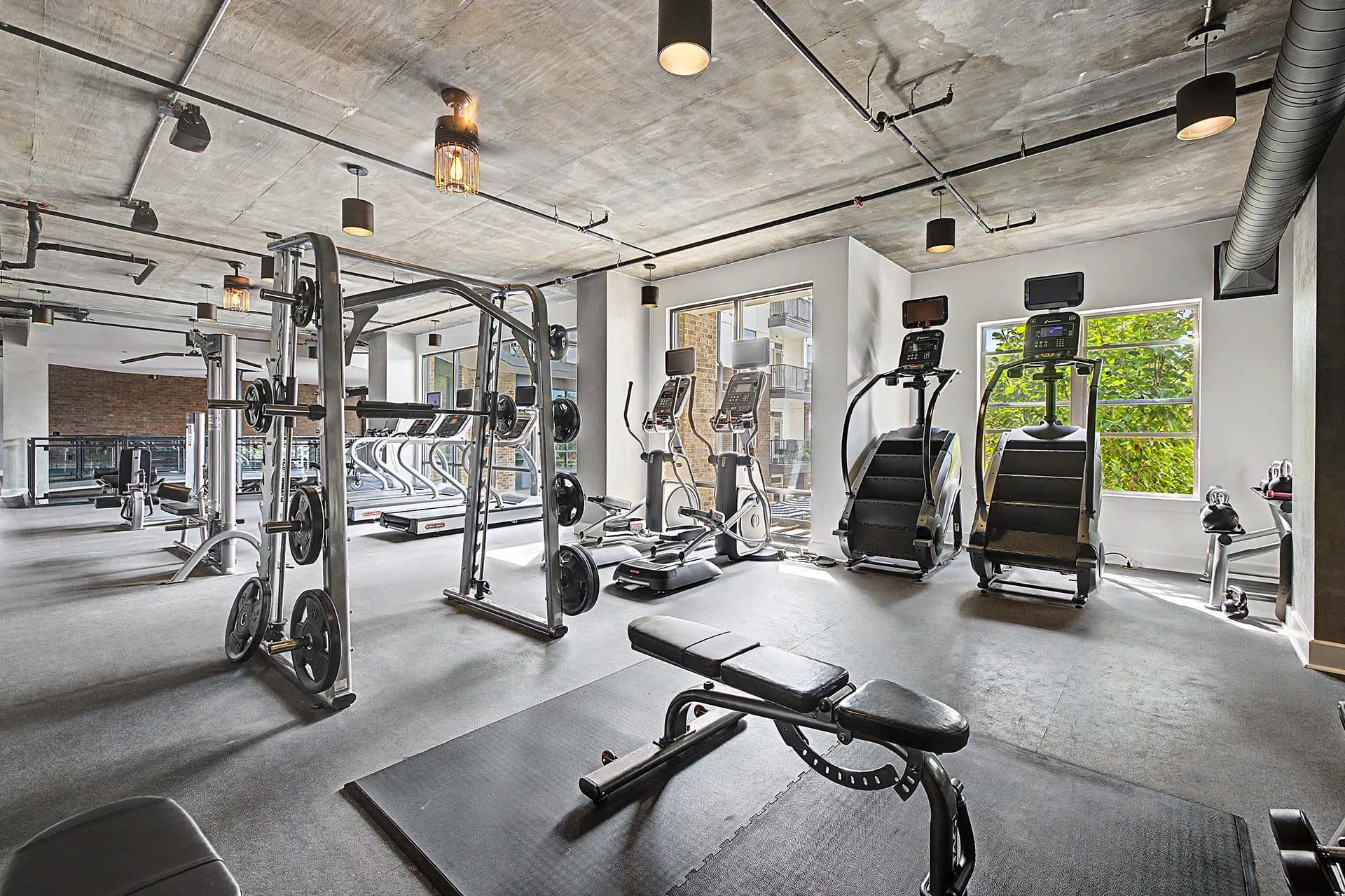 A gym with a variety of equipment including weights and cardio machines.