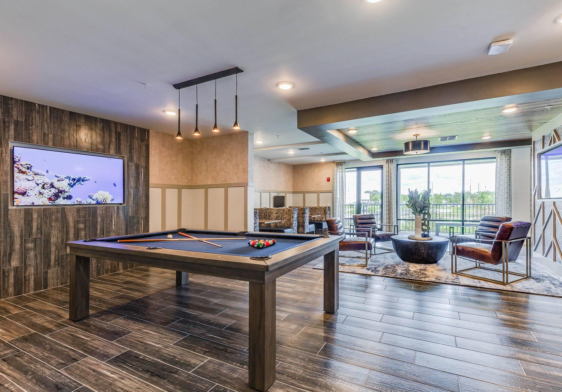 a game room with a pool table and a tv