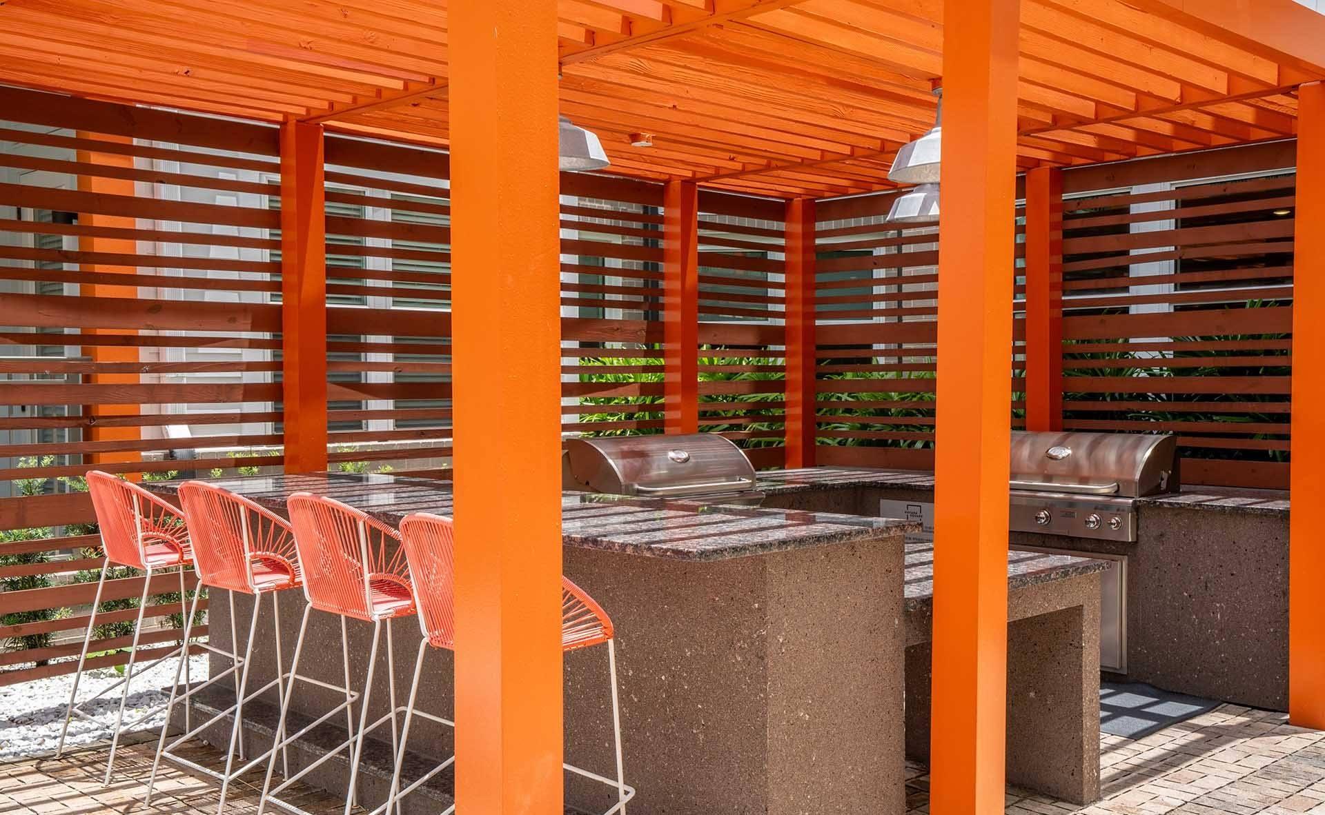 A patio with orange pillars and a table with chairs.